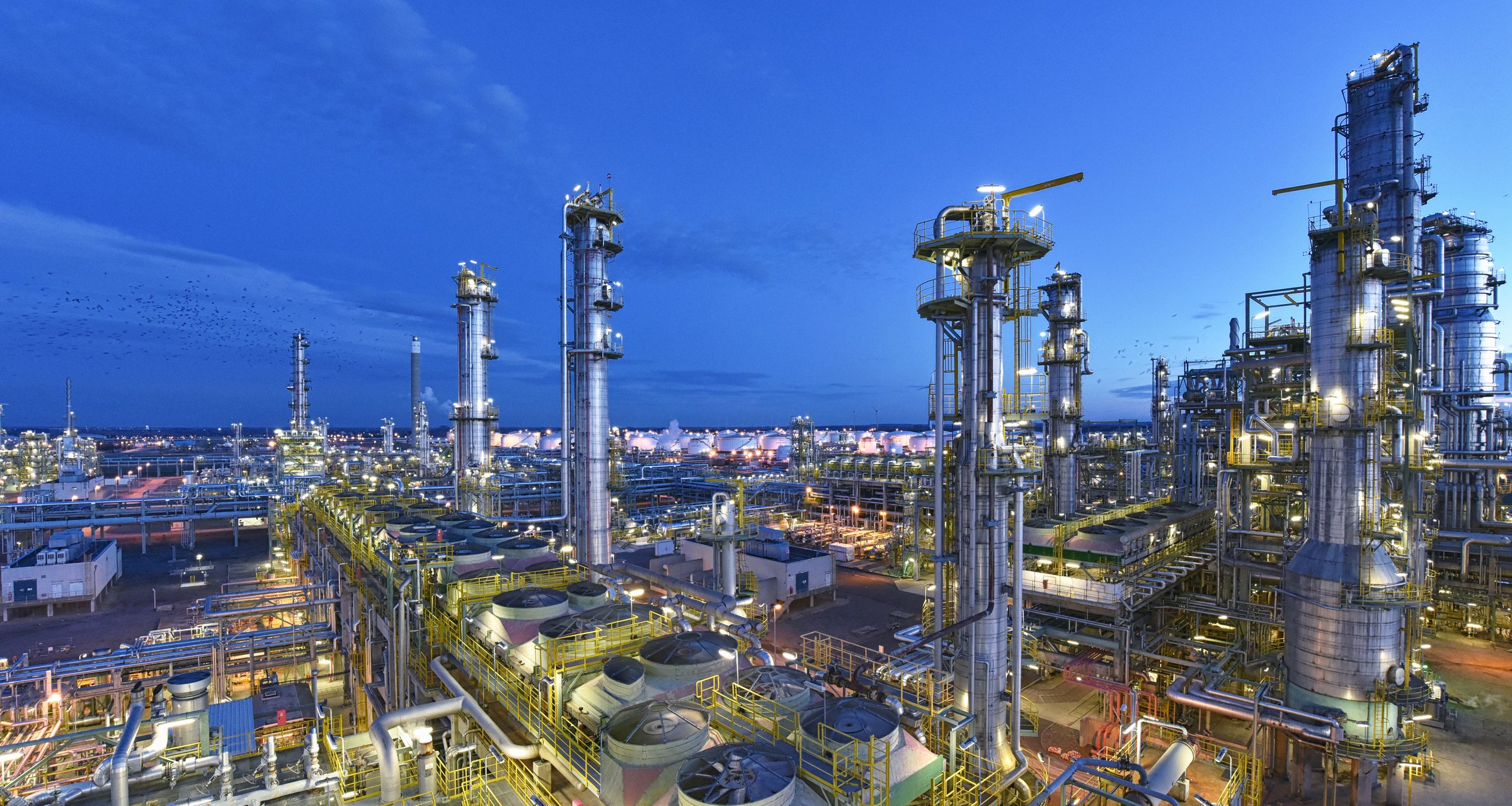 refinery - chemical factory at night with buildings, pipelines and lighting - industrial plant