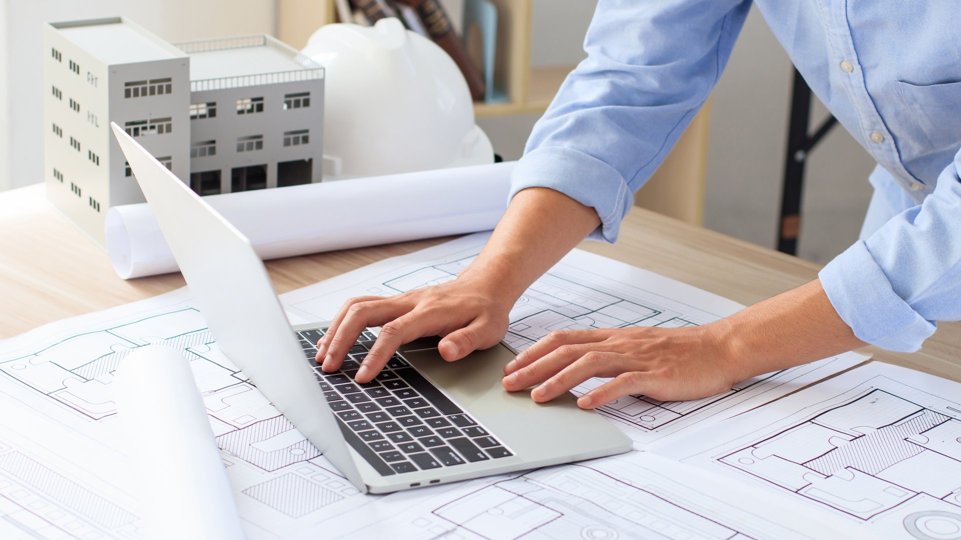 Engineer and construction concept. Engineer technician using laptop to drawing design building project on blueprints and analyzing of project types. Interior design and decoration ideas. Real estate