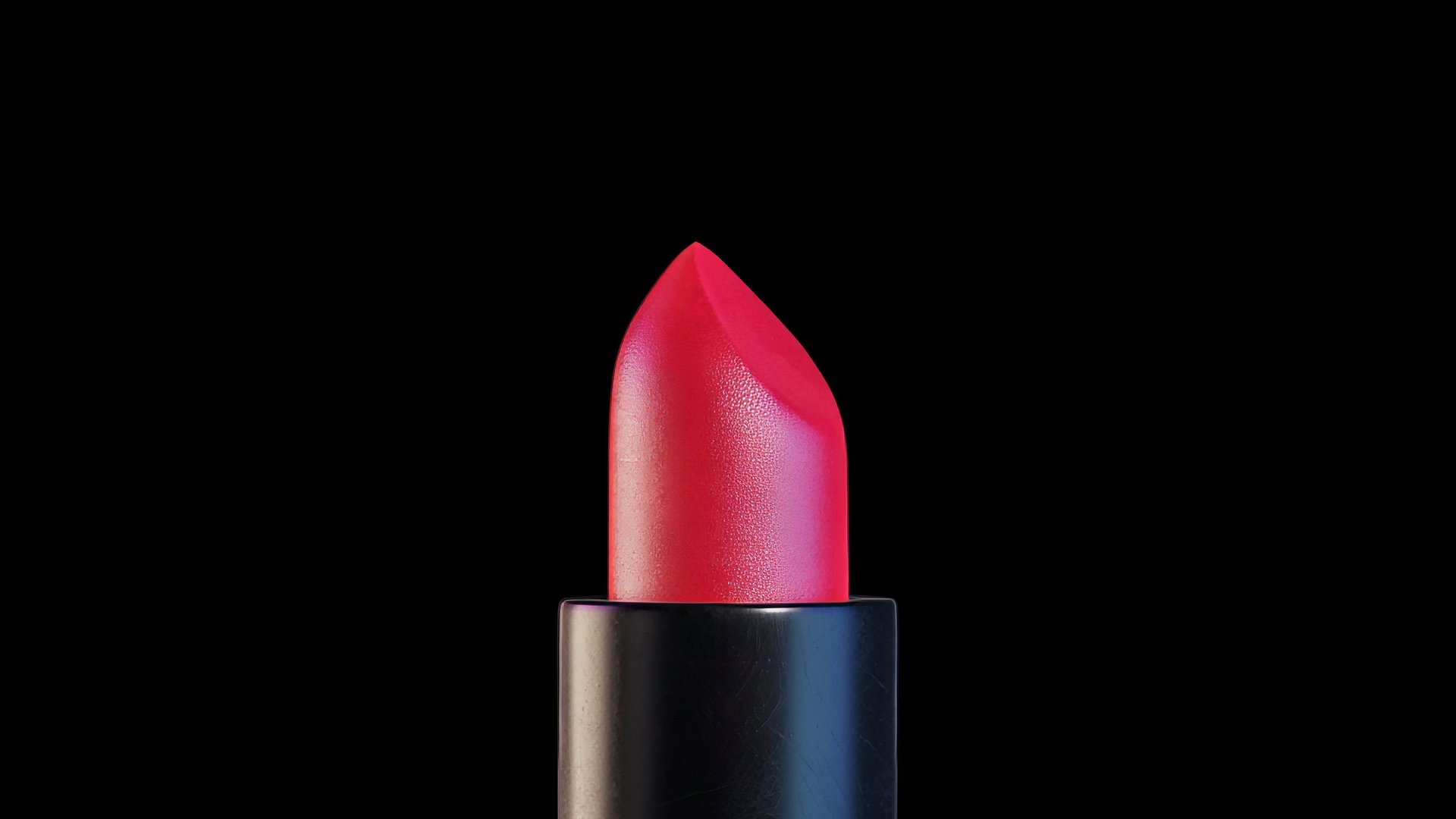 Sleek lipstick rotating slowly, revealing deep red color against stark black background, highlighting luxurious cosmetic design with sophisticated elegance and refined glamour