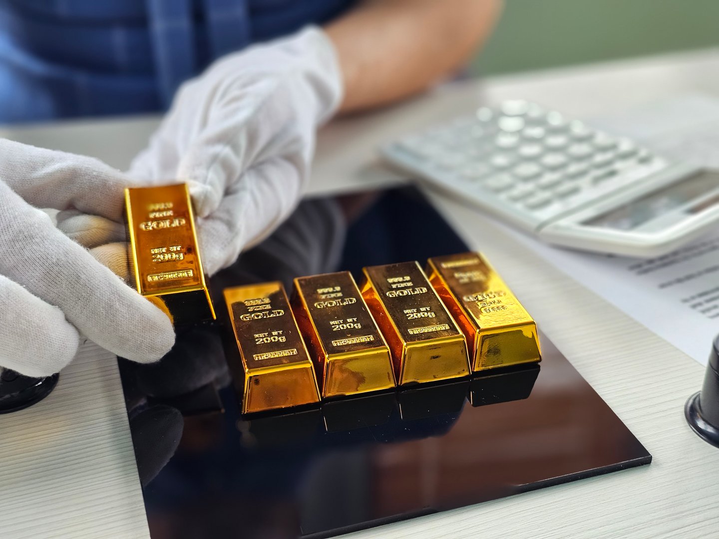 Gold bars being weighed and assessed at a financial facility during business hours
