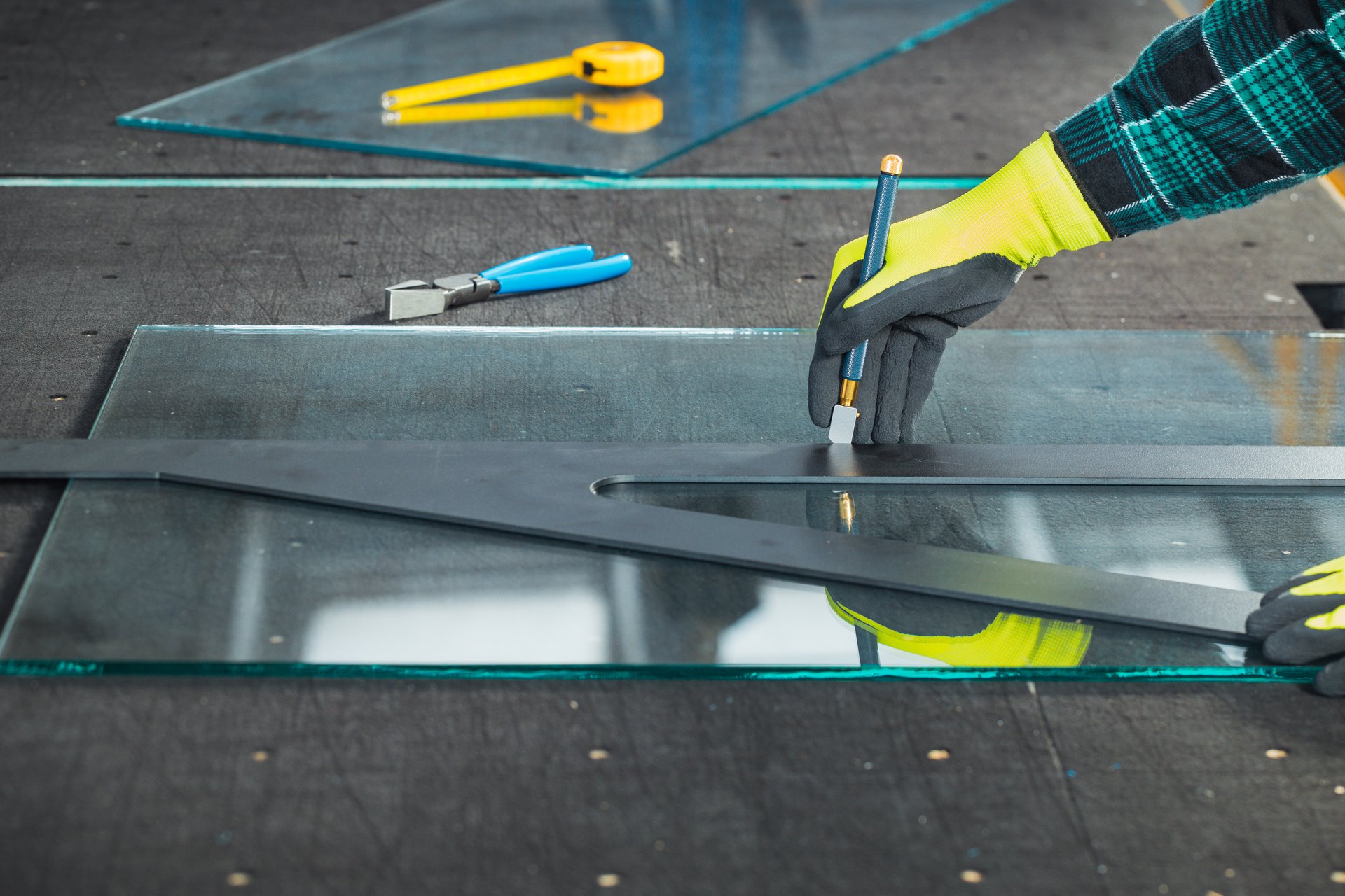 A glazier cuts thick glass on a specialized table, Concept, Work in a glass factory