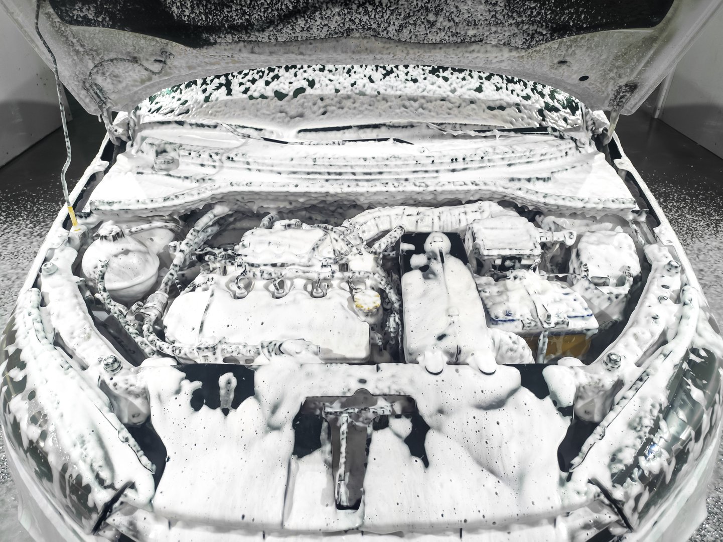 Cleaning the car engine with special foam. Washing the engine at a car wash. Maintaining cleanliness.