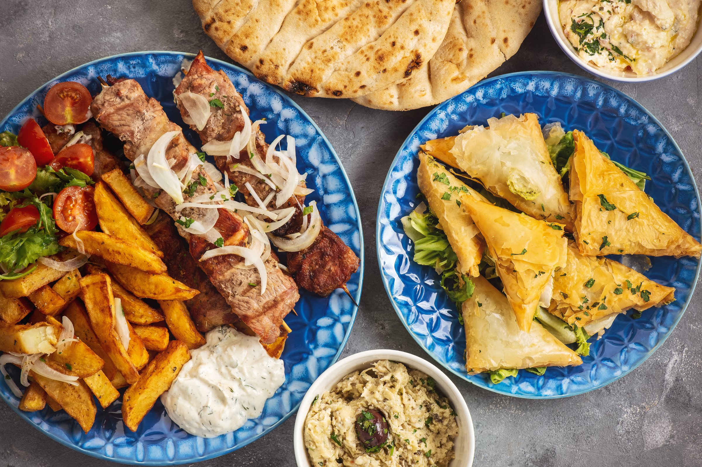 Souvlaki served with fried potatoes, tzatziki dip and pita bread, greek cuisine