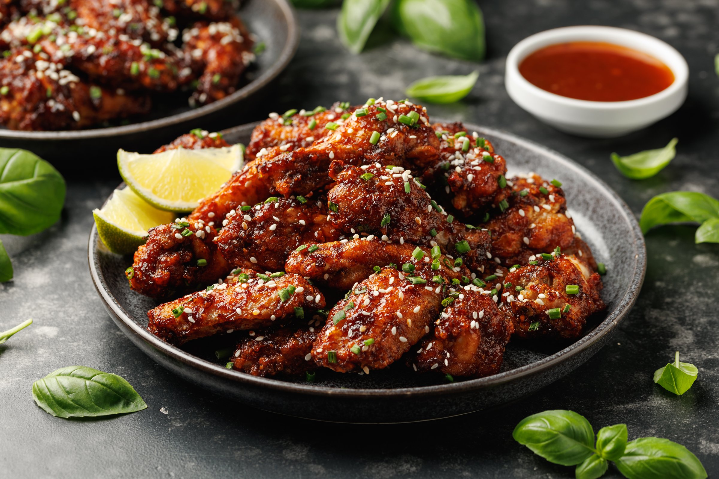 Spicy korean chicken wings with sesame seeds and chives.