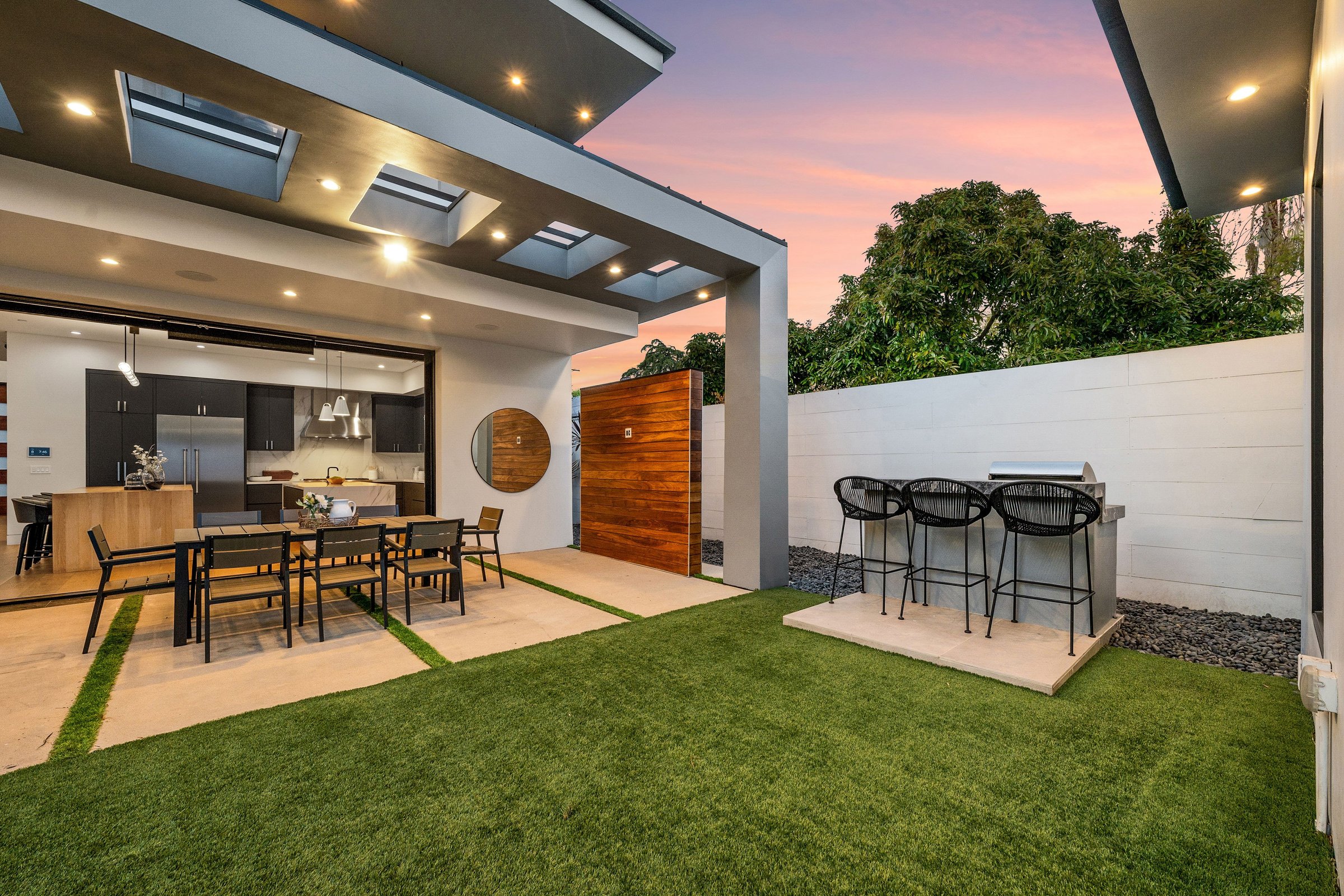 Twilight photo of a modern luxury home with pool, patio, and sleek architectural lines in a suburban setting