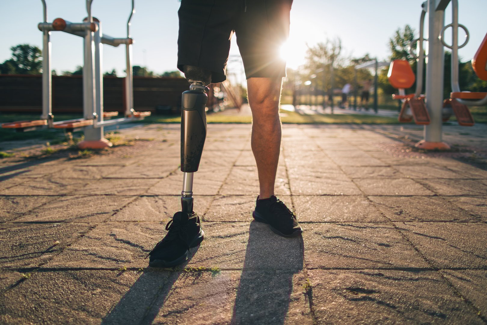 Close-up  of athlete amputee's leg, showcasing a prosthesis during exercising in the open outdoor gym.
