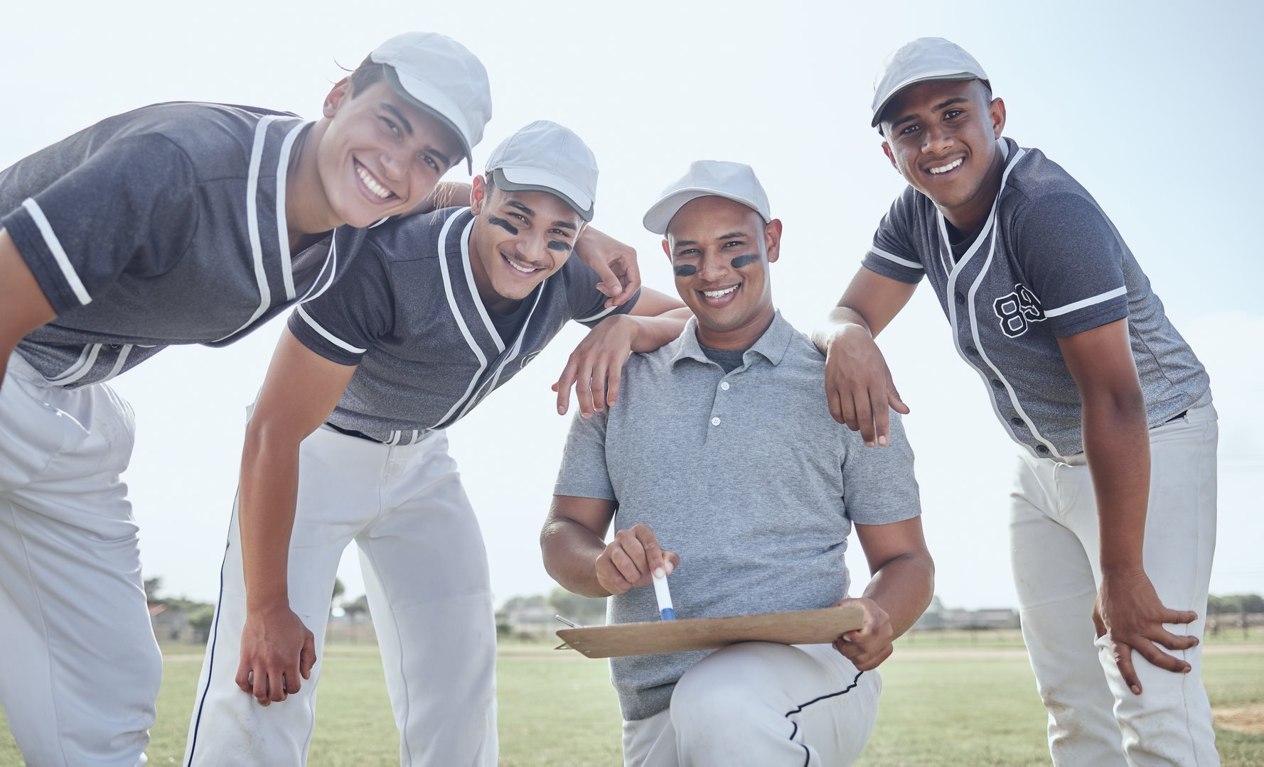 Baseball team, sports coaching and strategy, planning and collaboration for winner motivation on training pitch. Portrait baseball players, trainer and happy group brainstorming game ideas for goals