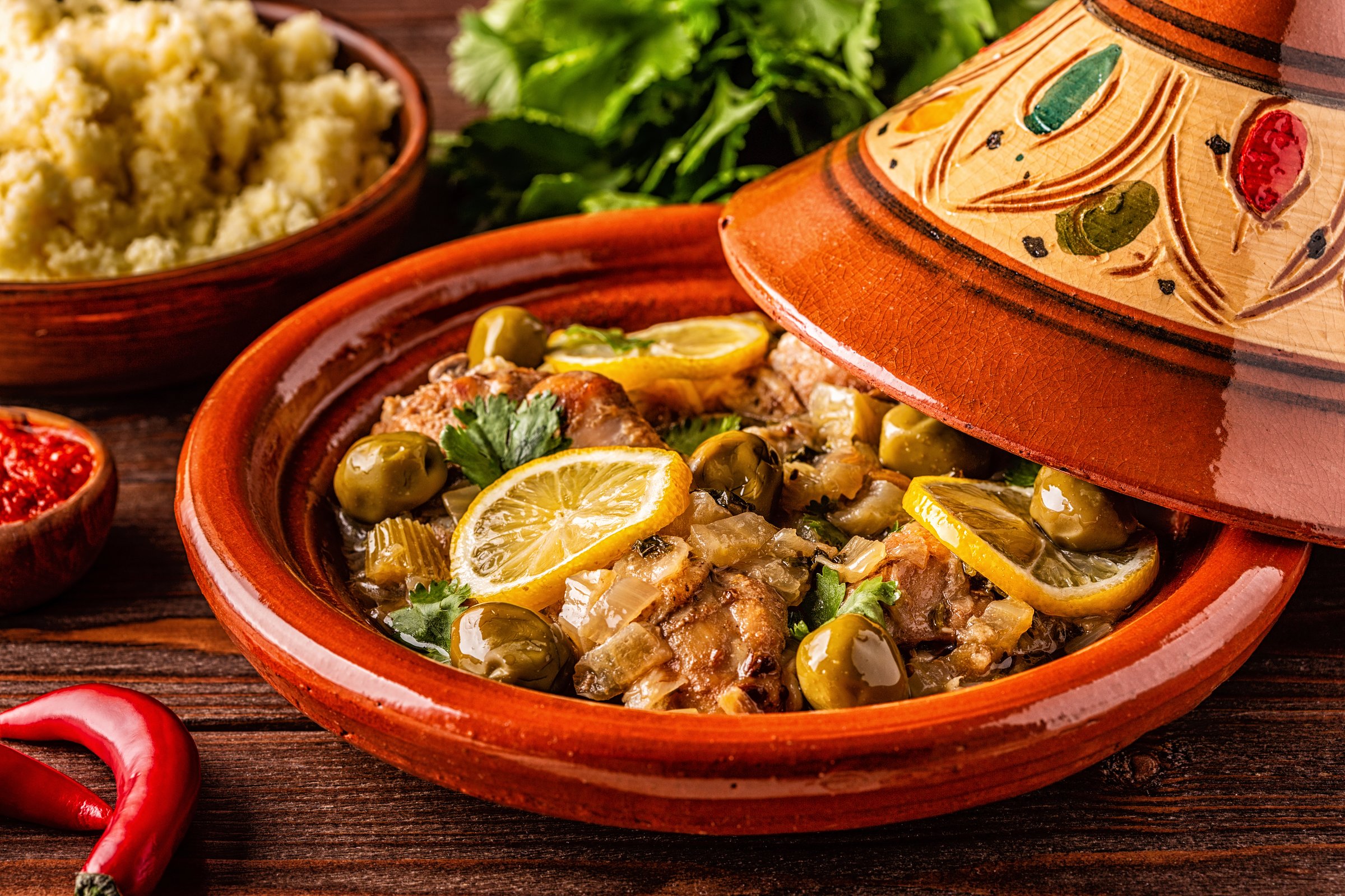 Traditional Moroccan chicken tagine with olives and salted lemons, selective focus.