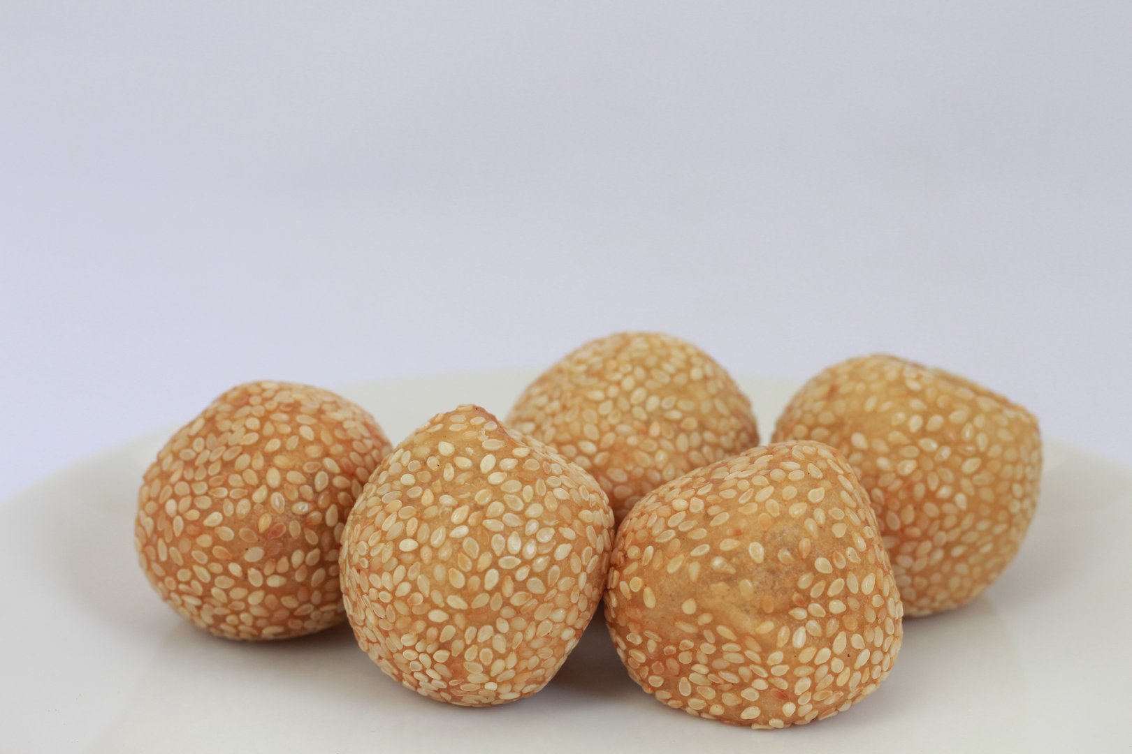 Onde-onde or jian dui is a type of cake that is popular in Indonesia. Onde-onde is a traditional food from Indonesia. Onde-onde served on a white plate