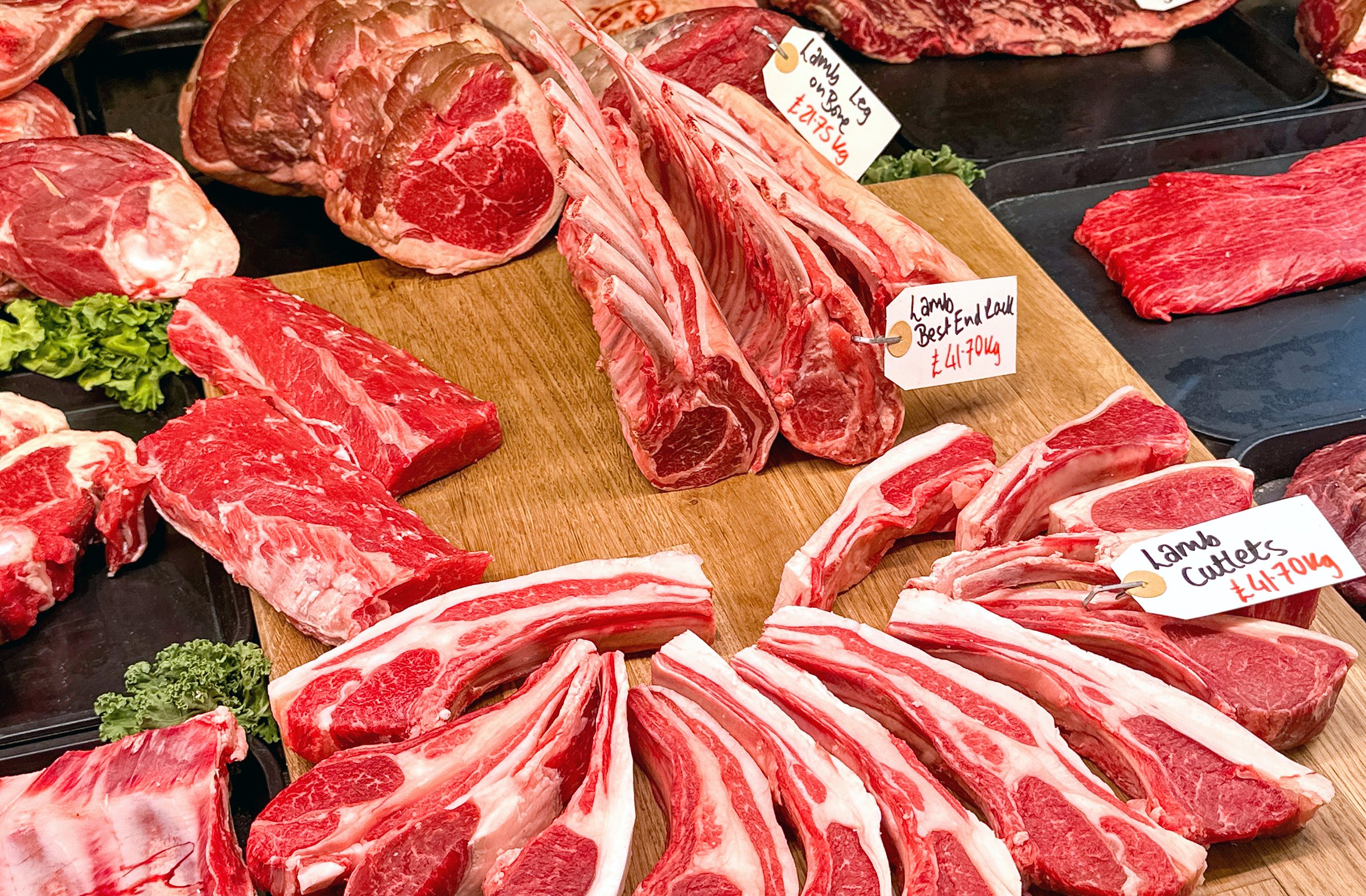 Selection of joints of fresh lamb on a butcher's stall in a market. No people.