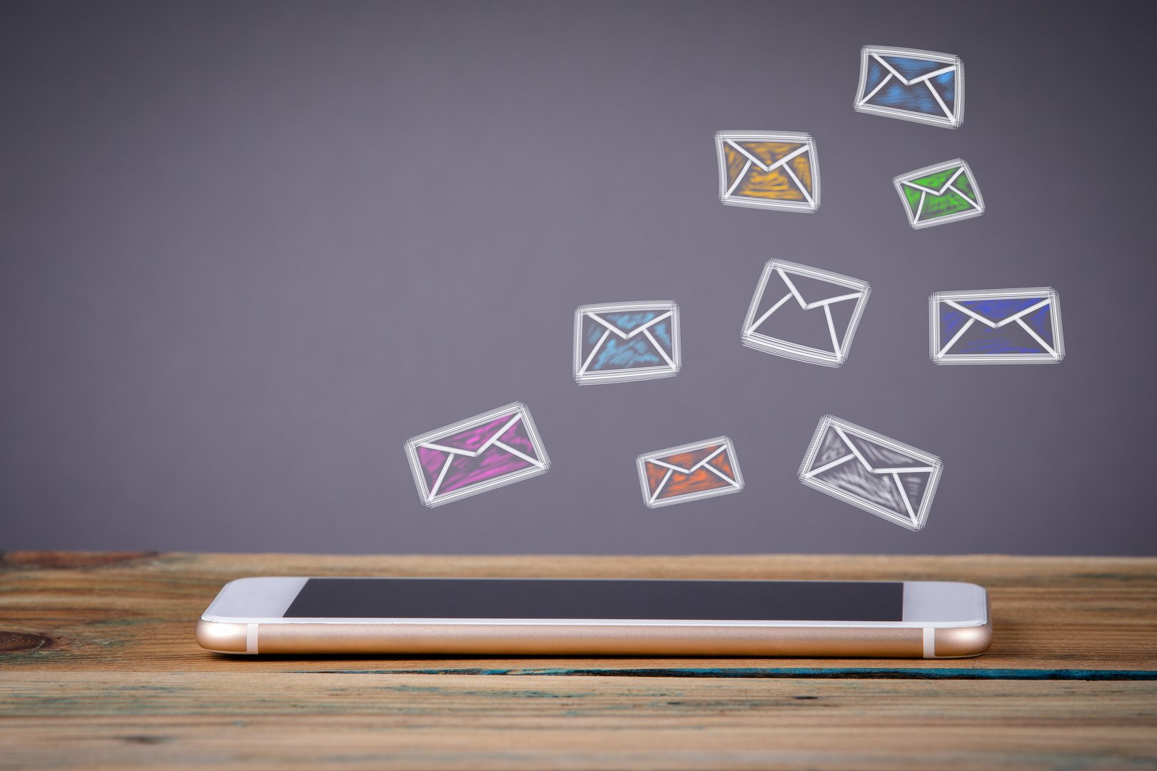 e mail marketing concept. Media Technology concept. Mobile phone on a wooden table and a gray background