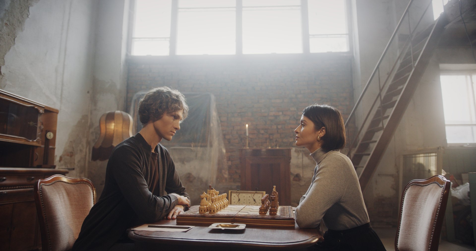 A young man and woman deeply engaged in a chess match in a vintage-style room. The scene captures the intense concentration of both players, with warm lighting, rustic decor, and a chessboard as the focal point.