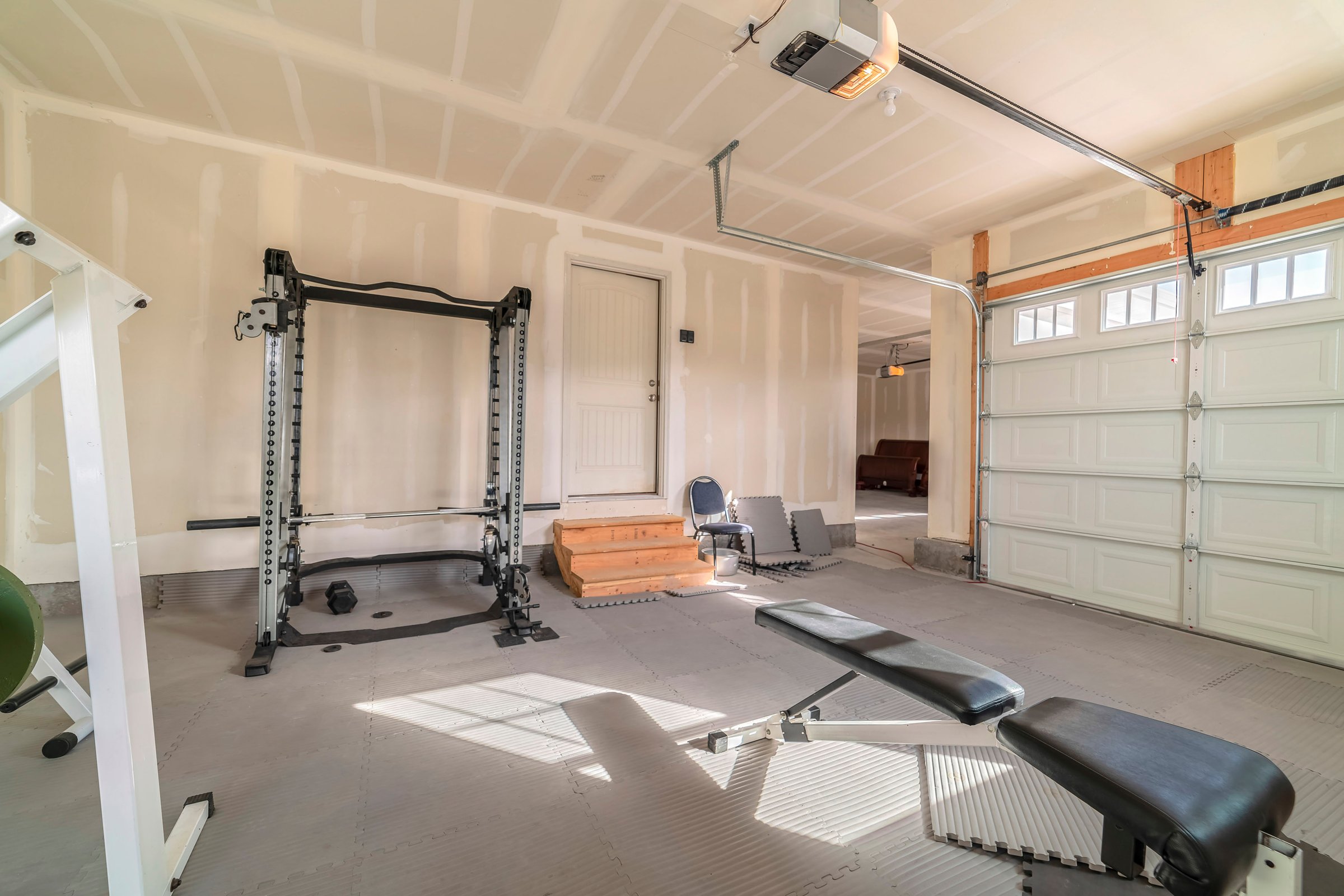 Premium home gym with power rack, dumbbells, and weight bench in modern garage