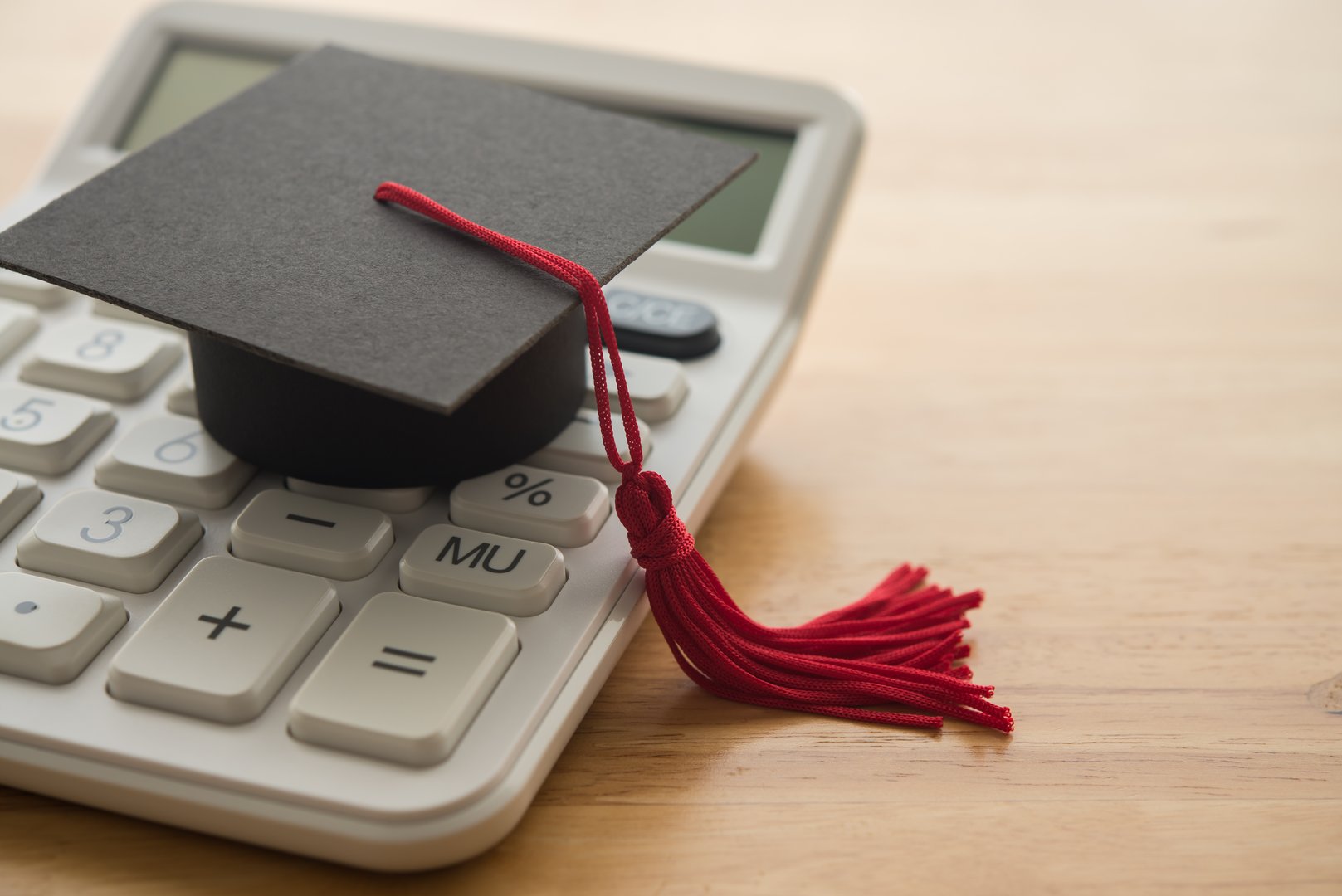 Mortarboard on white calculator. Money financial management and planning for education, student debt or loan, repayment, budget cost calculate home, finance concept. Education is investment for future