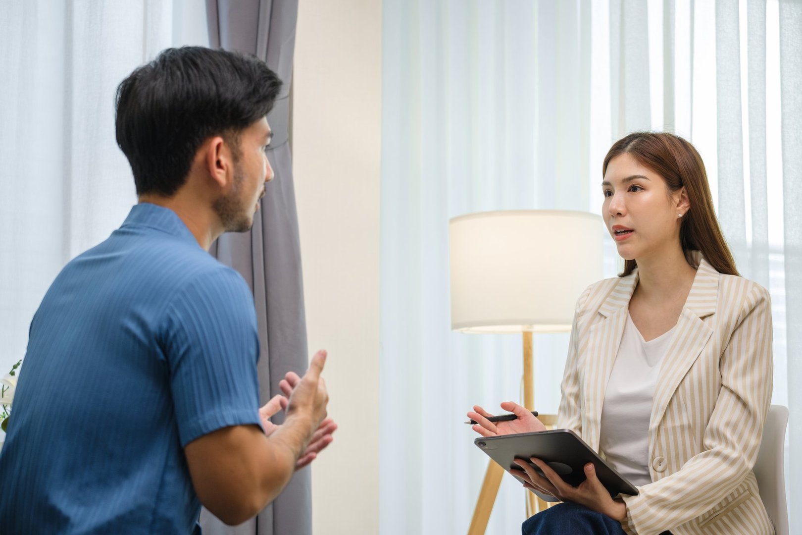 asian man engaged in a one-on-one therapy session with a professional counselor in a calm and supportive environment