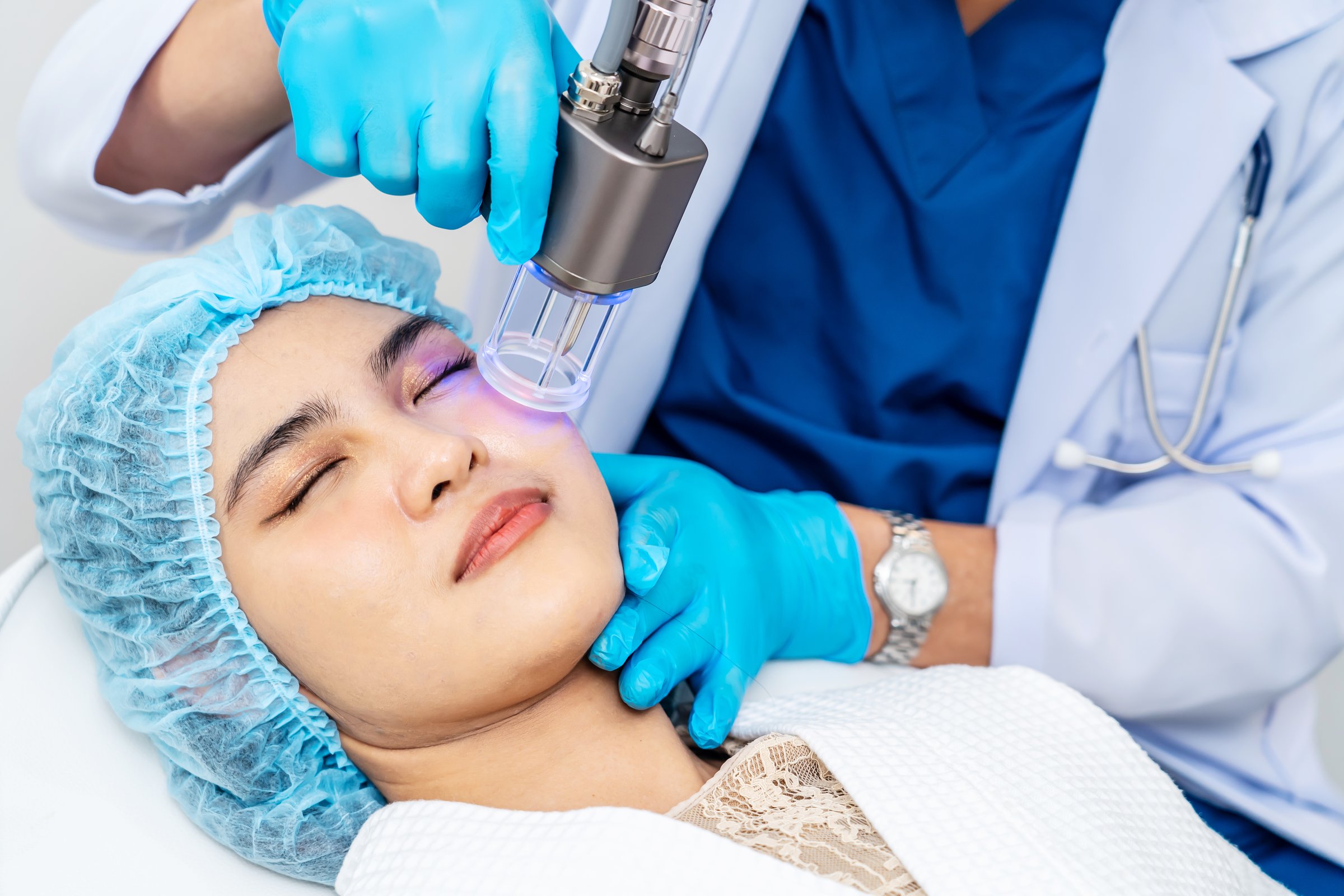 Asian Doctor doing laser on the woman face at beauty clinic. Beautiful woman having facial skin care treatment at beauty clinic, anti-aging facial