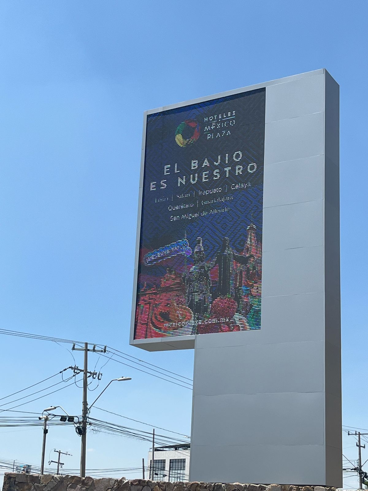 A large digital billboard advertising "El Bajío es Nuestro" in Spanish, promoting various cities and hotels in Mexico.