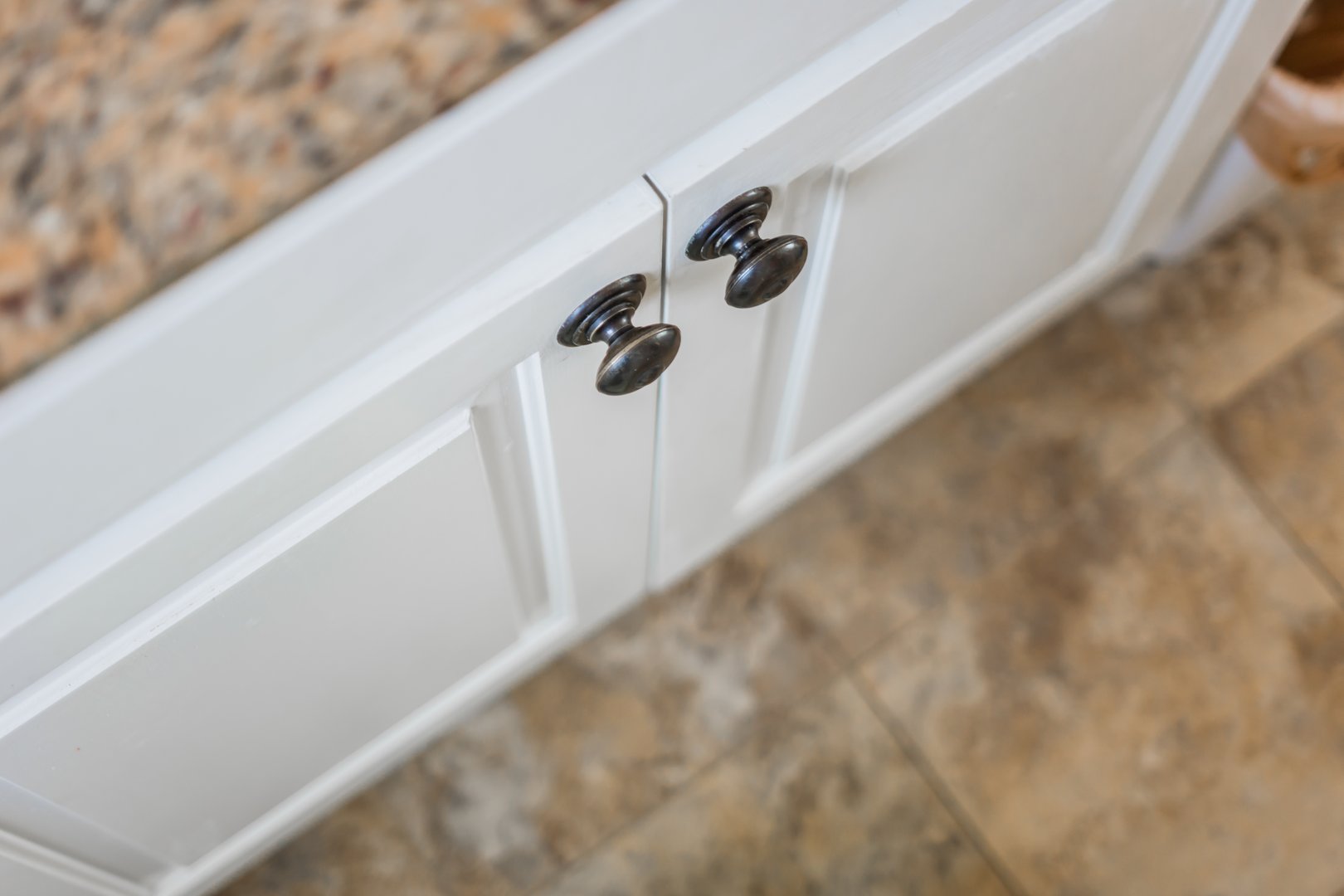 White cabinet, bronze knobs, granite counter