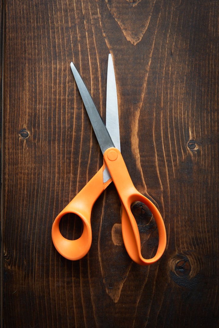 orange Scissors on aged wooden table