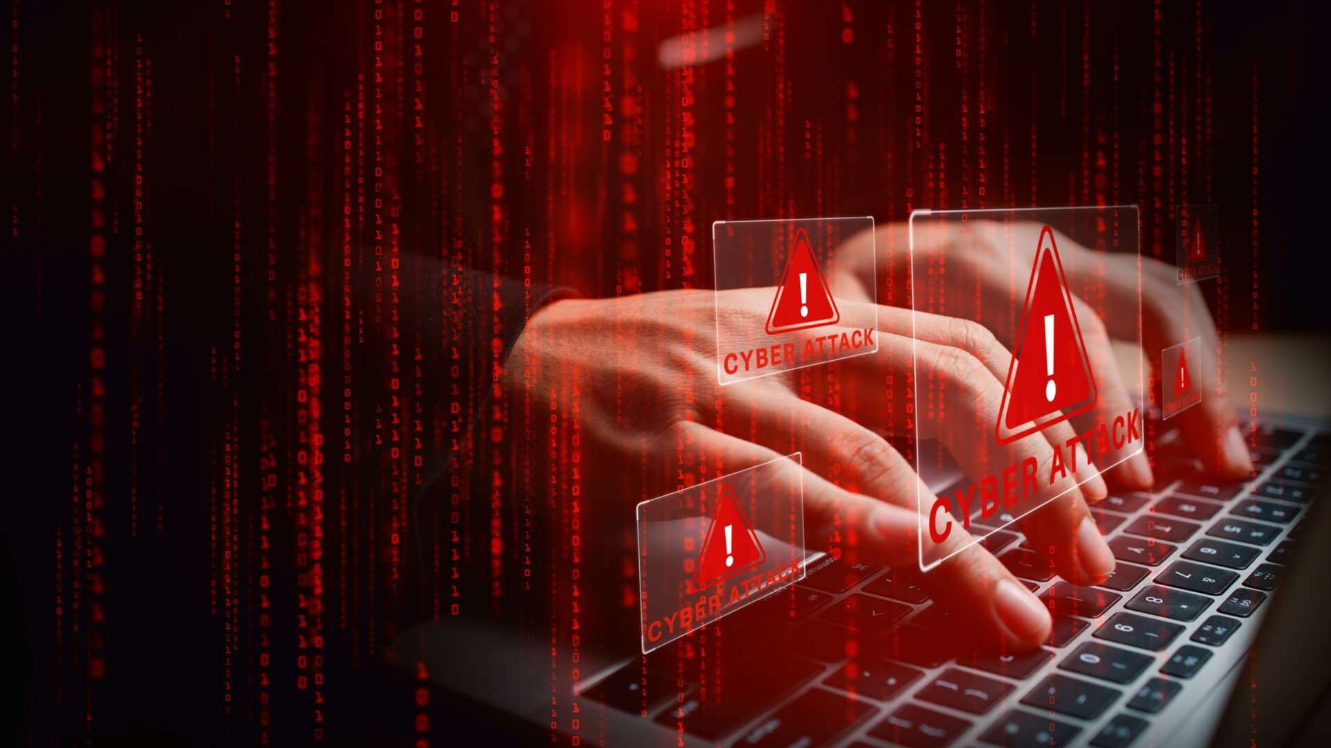 Laptop with hands typing amid glowing cyber attack alerts and red binary code, symbolizing hacking, data breach, and cybersecurity threats, 3d Rendering