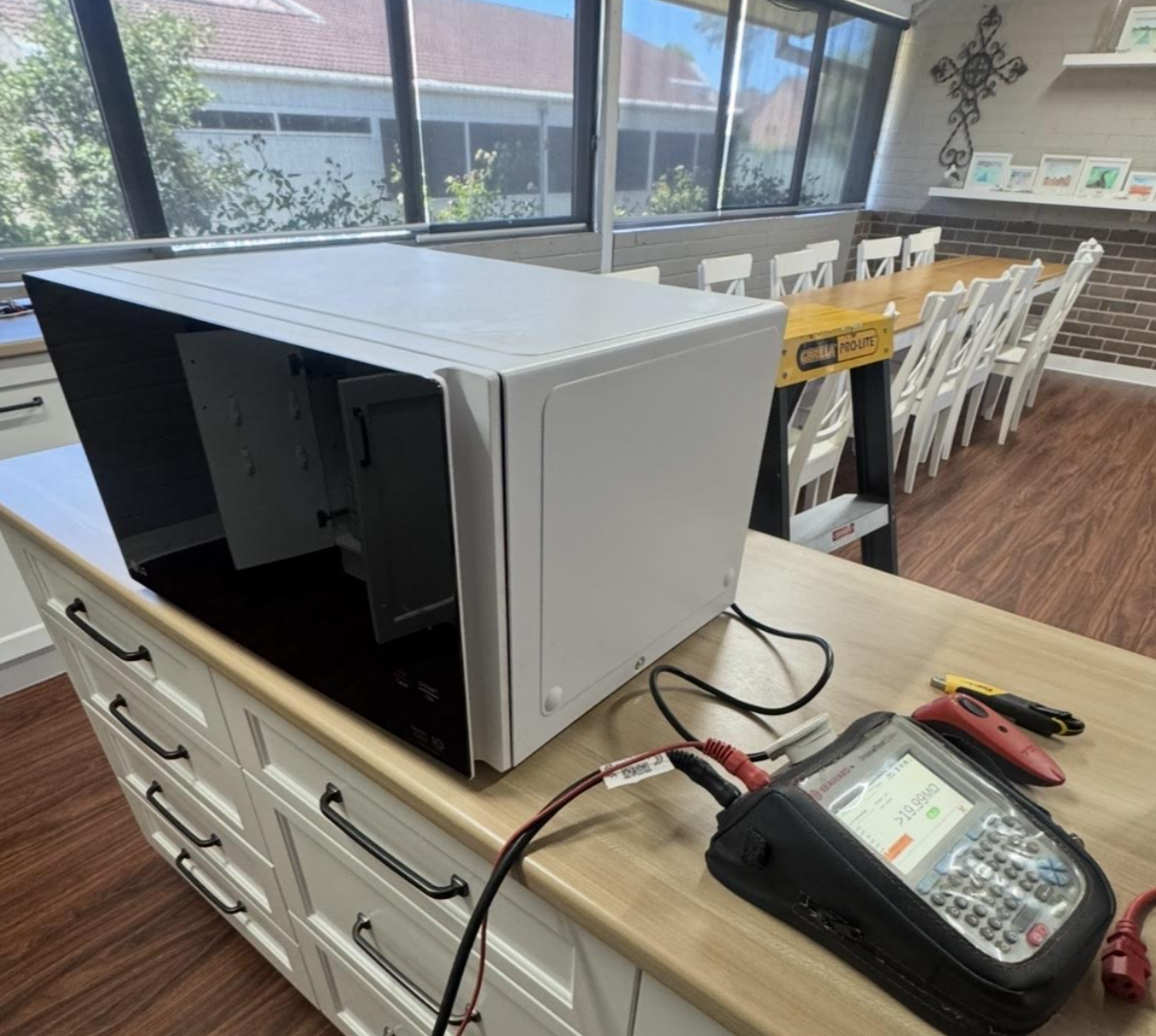 Professional plumber taking notes on a clipboard while standing in a modern kitchen, ready to provide plumbing services