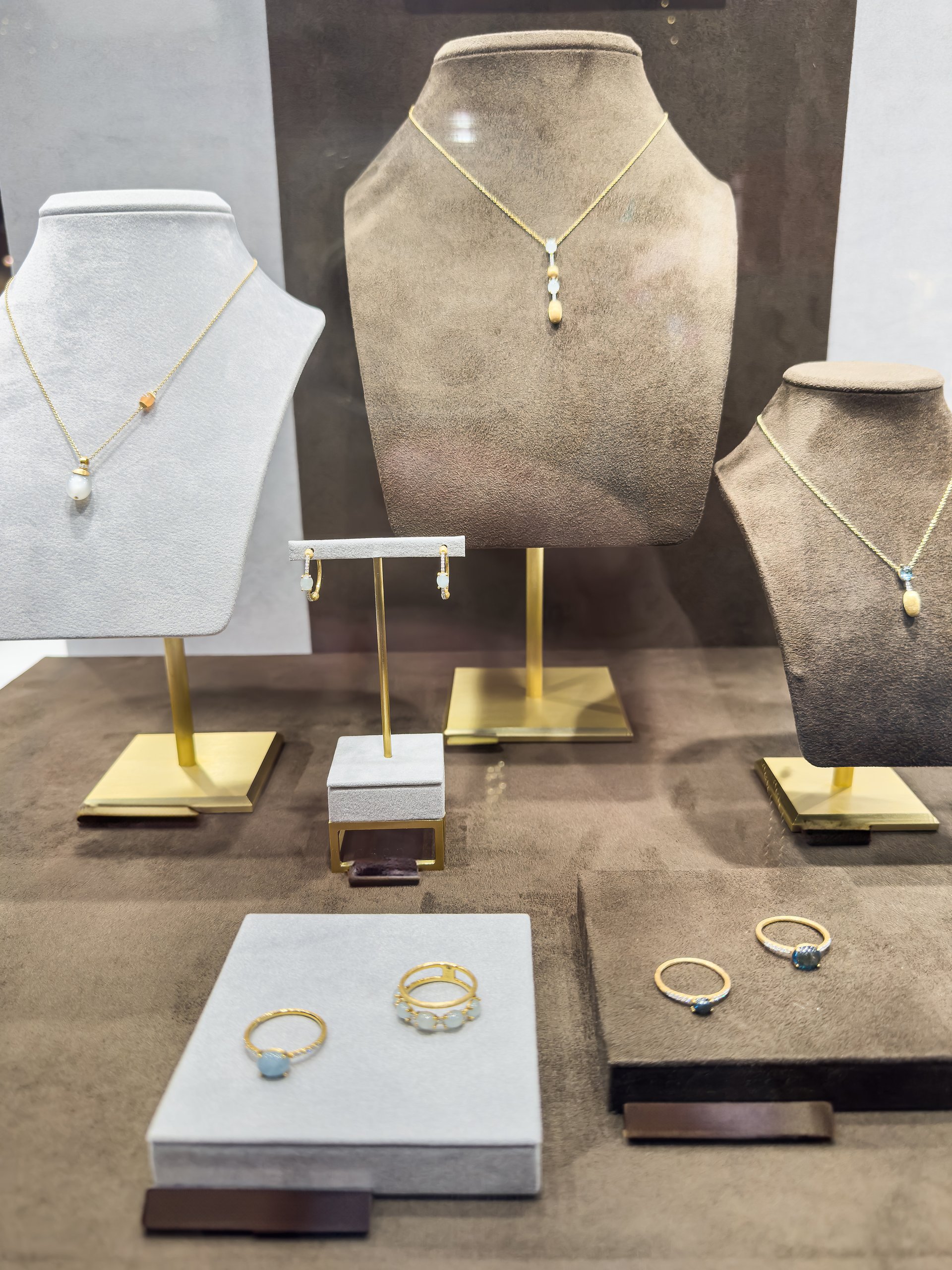 Golden pendants and earring with dimonds on display of jewelry store. Nobody