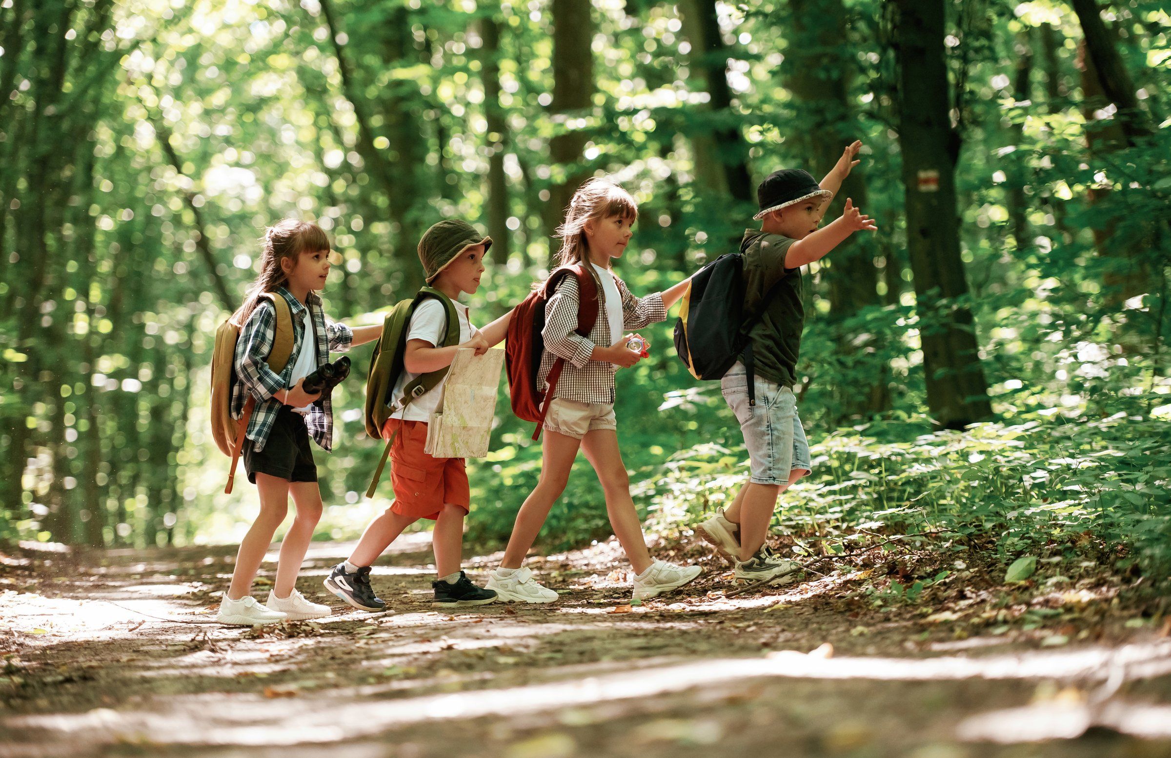Discovering new place. Kids in forest at summer daytime together.