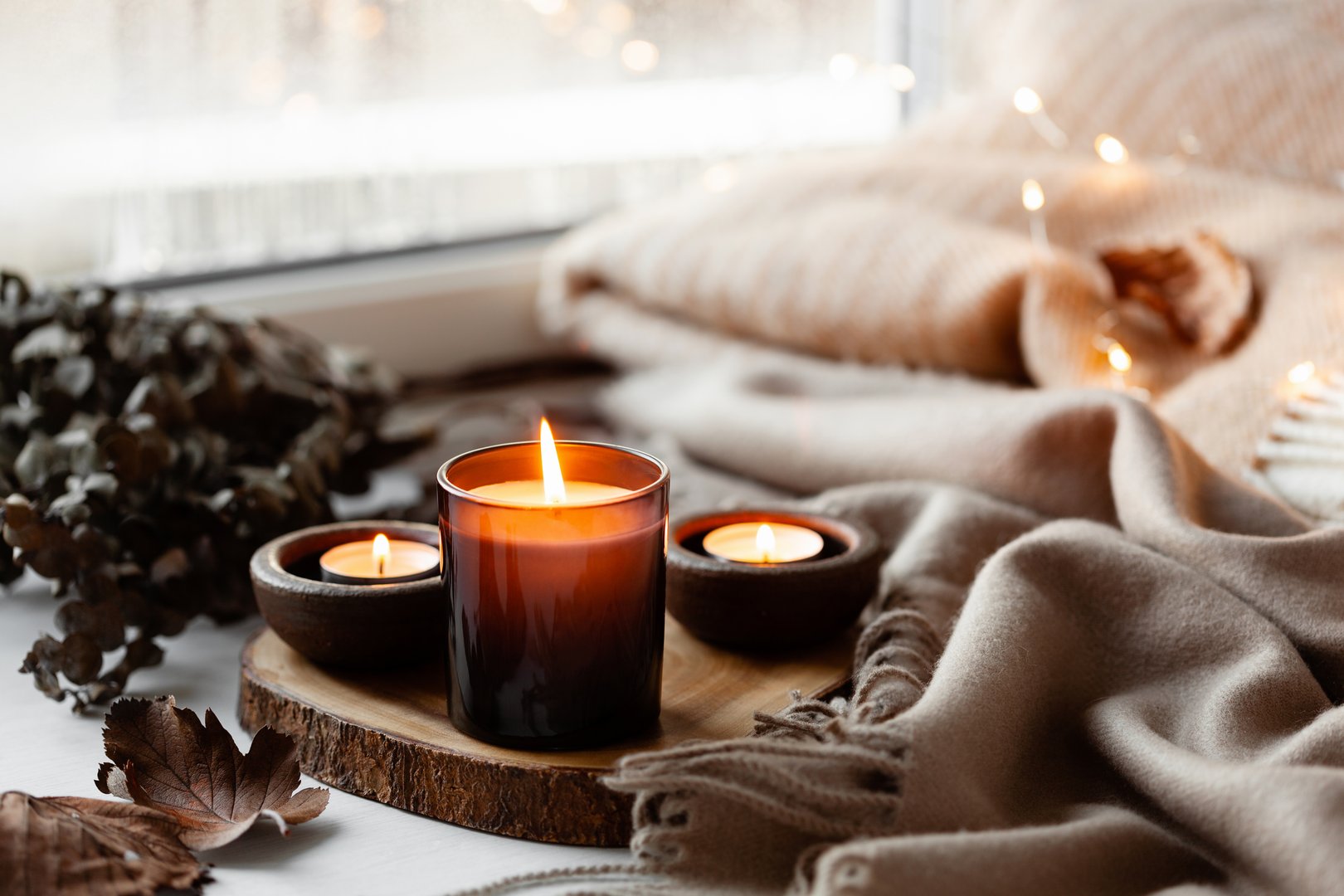 warm cozy window arrangement, winter or autumn concept, candles throw lights