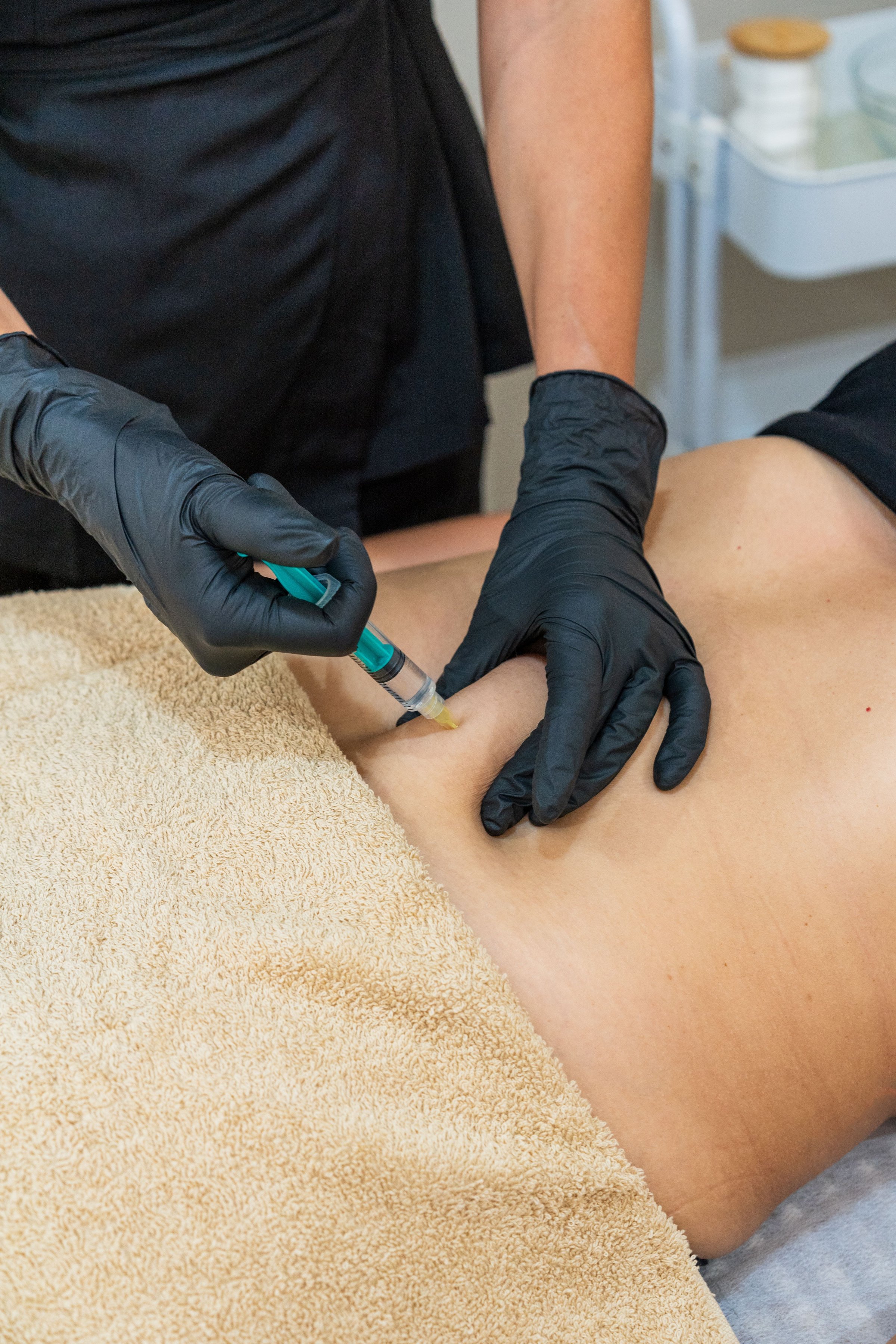 Skilled professional performing body mesotherapy injection on abdomen for aesthetic body treatment.