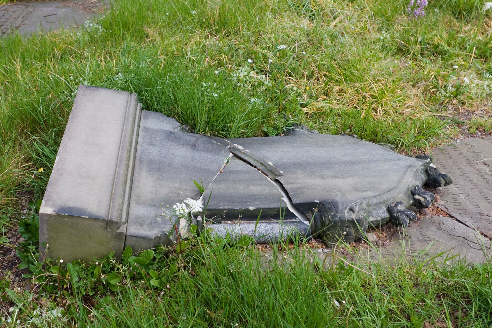 Old gravestone in churchyard cemetry, fallen over and smashed in half. Location is Knutsford, Cheshire, UK.