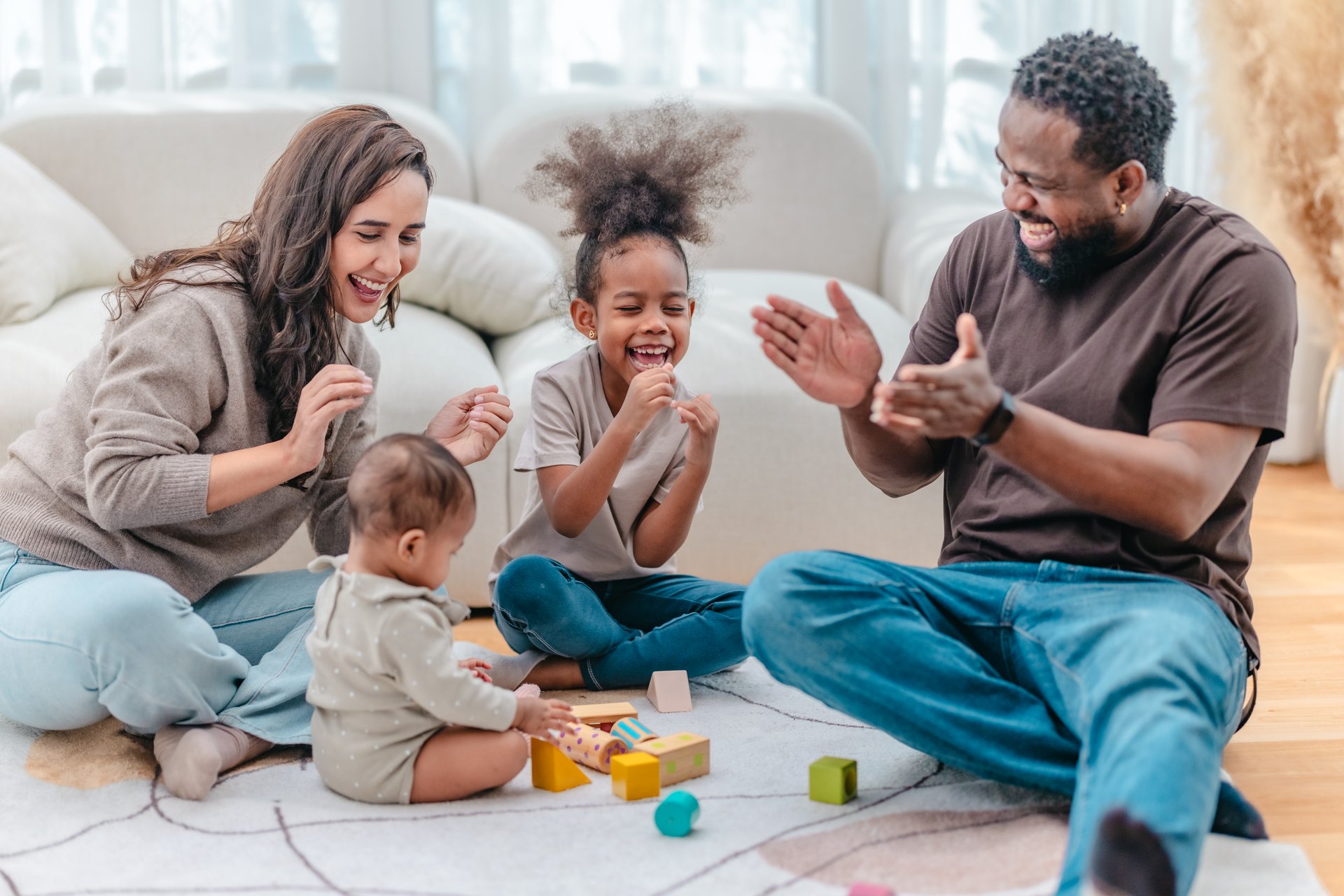 Heartwarming scene of diverse family spending quality time together in living room. The group includes parents and two children, showcasing love, connection, togetherness in modern family setting