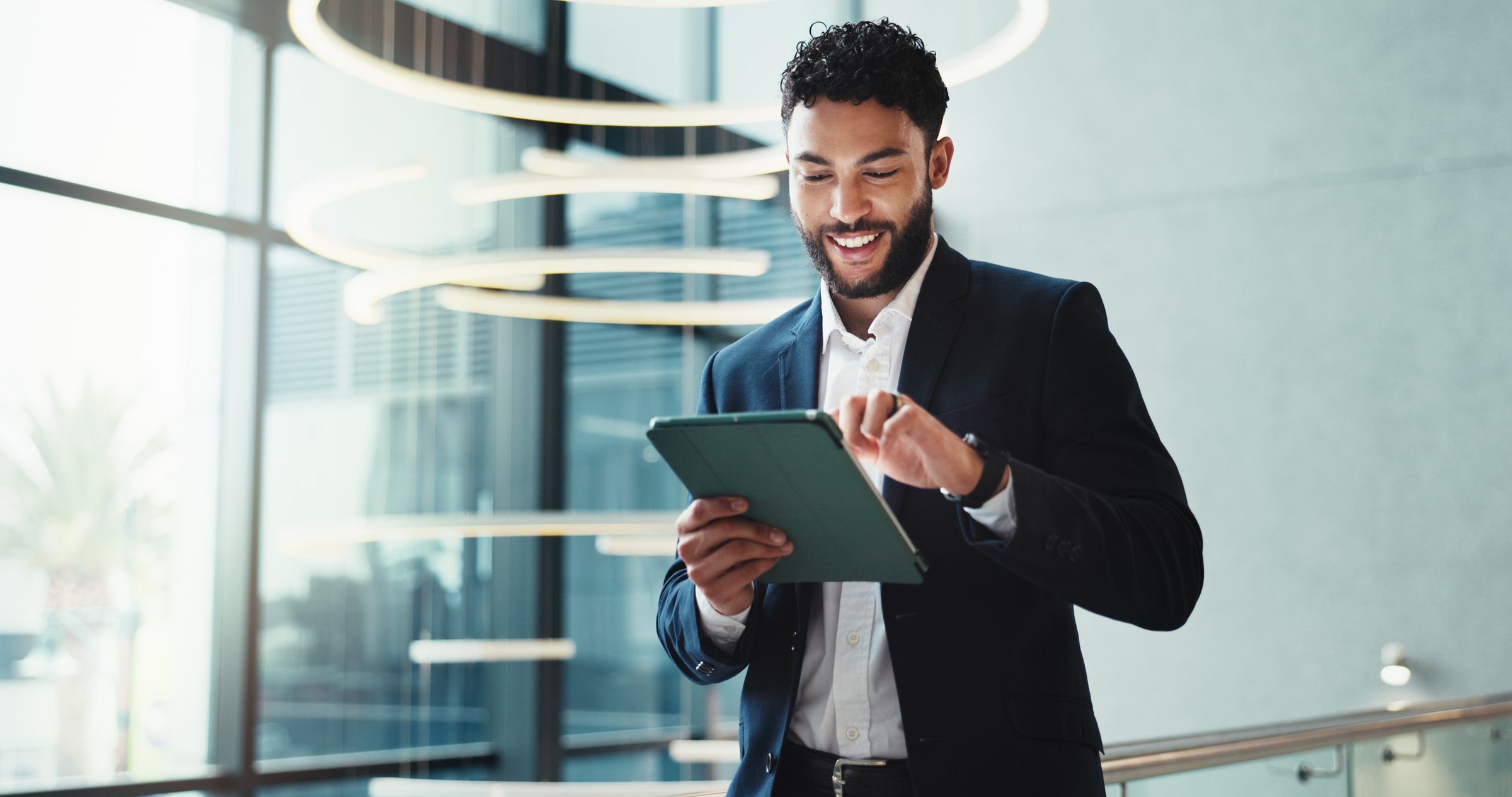 Hotel, lobby and businessman with tablet for report, schedule information or conference hall planning. Seminar, employee and keynote speaker with smile for networking, research and online review