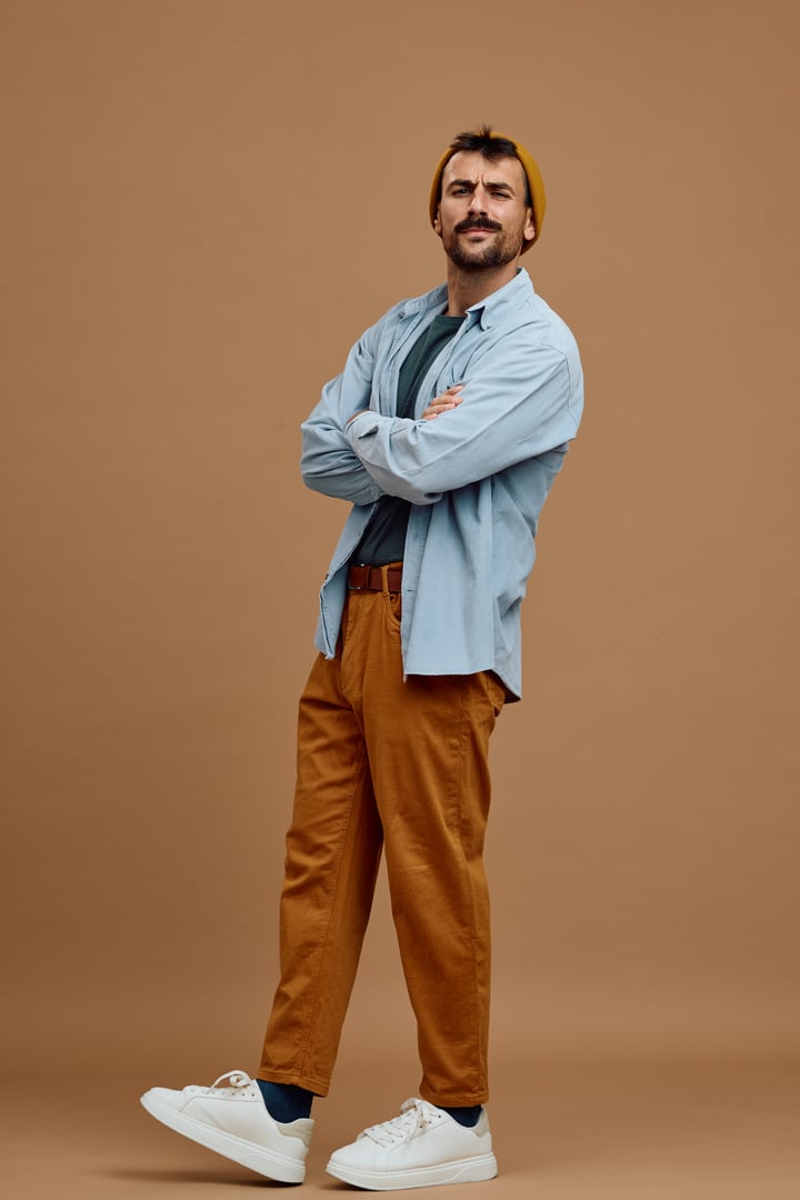 Self-confident man standing with his arms crossed and looking at camera.