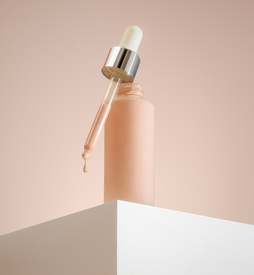 Liquid BB foundation in a dropper bottle on pink background exemplifies modern beauty and the latest cosmetic trends