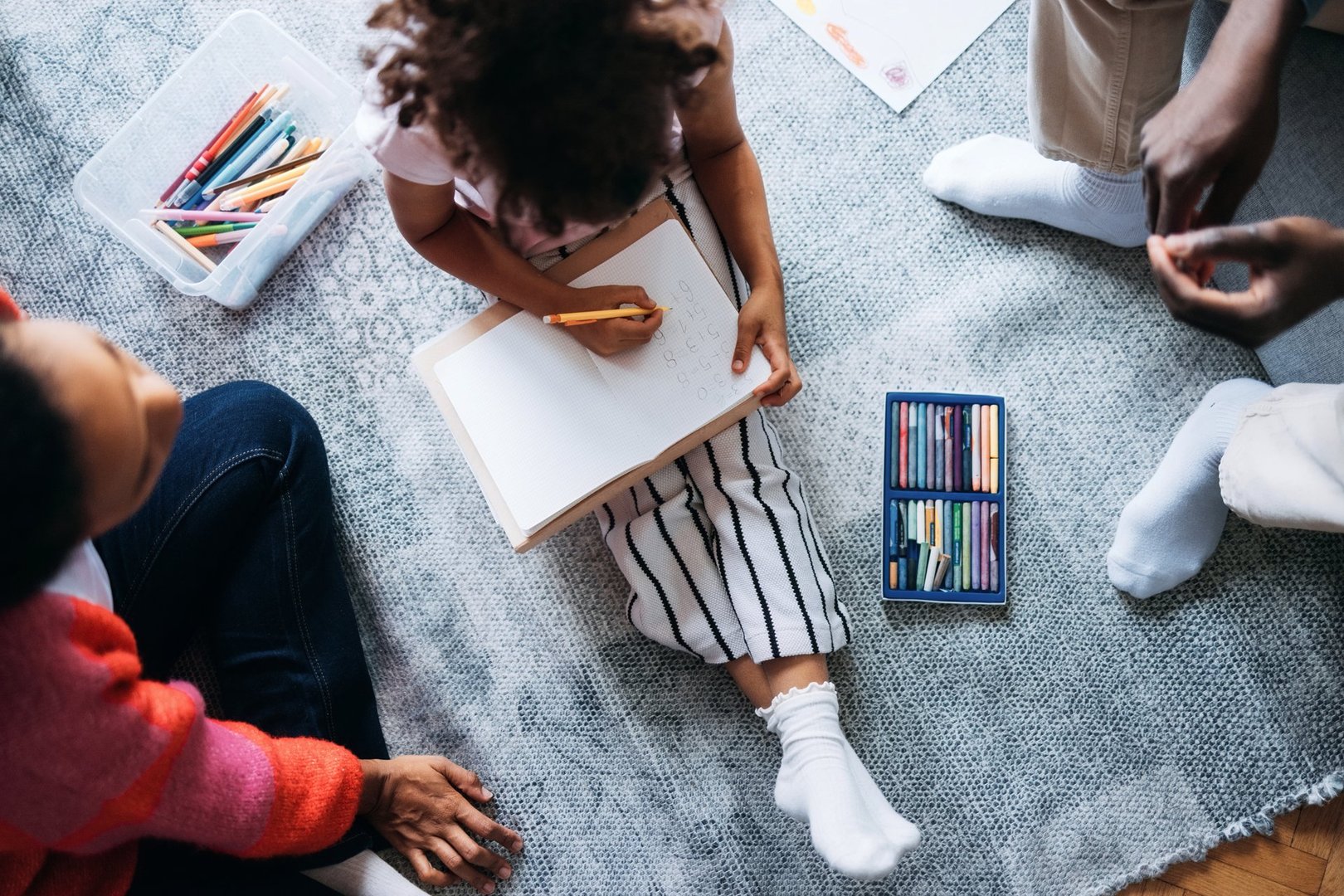 A family spending quality time with art supplies, fostering creativity and connection through drawing and coloring together.