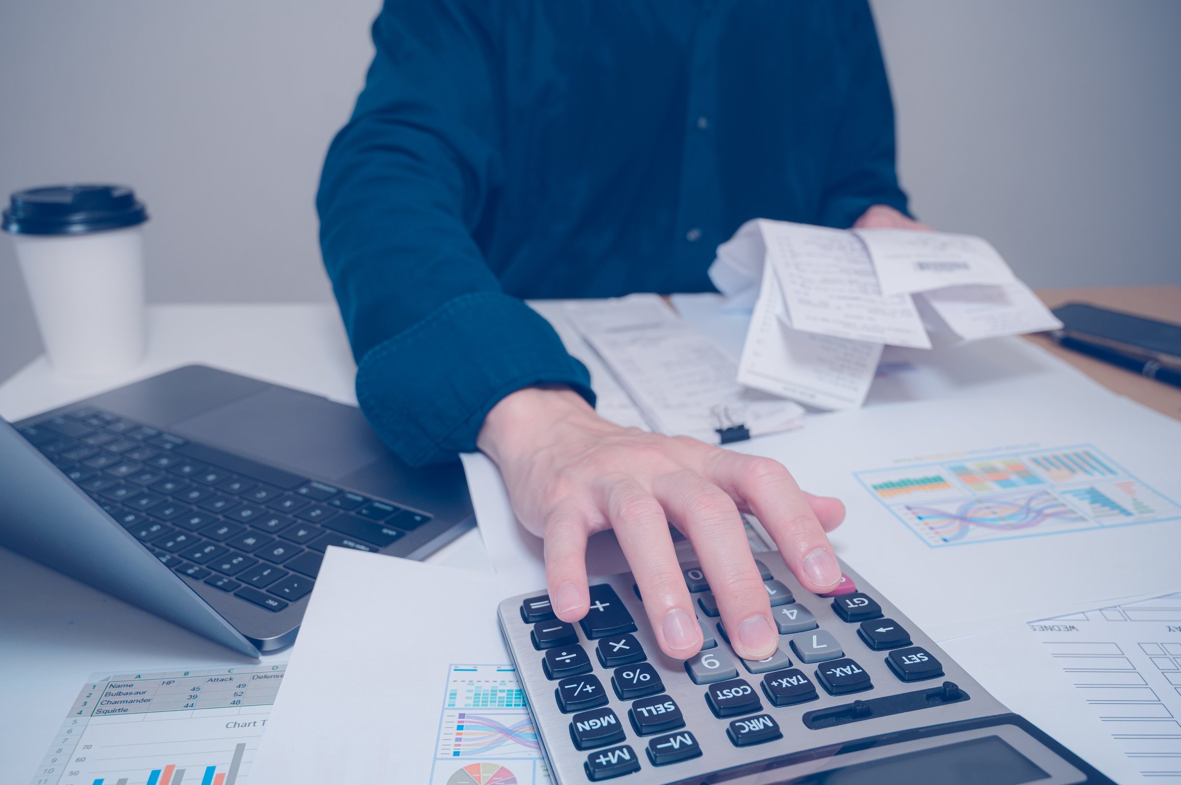 Close up of businessman hand calculating budget checking bills, using calculator to calculate home finance budget management. Doing finance, budgeting and tax calculation, monthly expenses