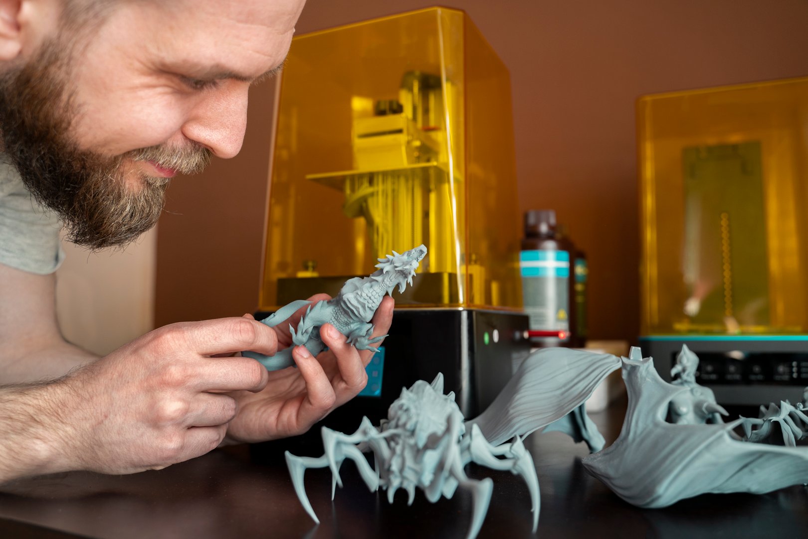 Man holding plastic figurines made with 3d printer