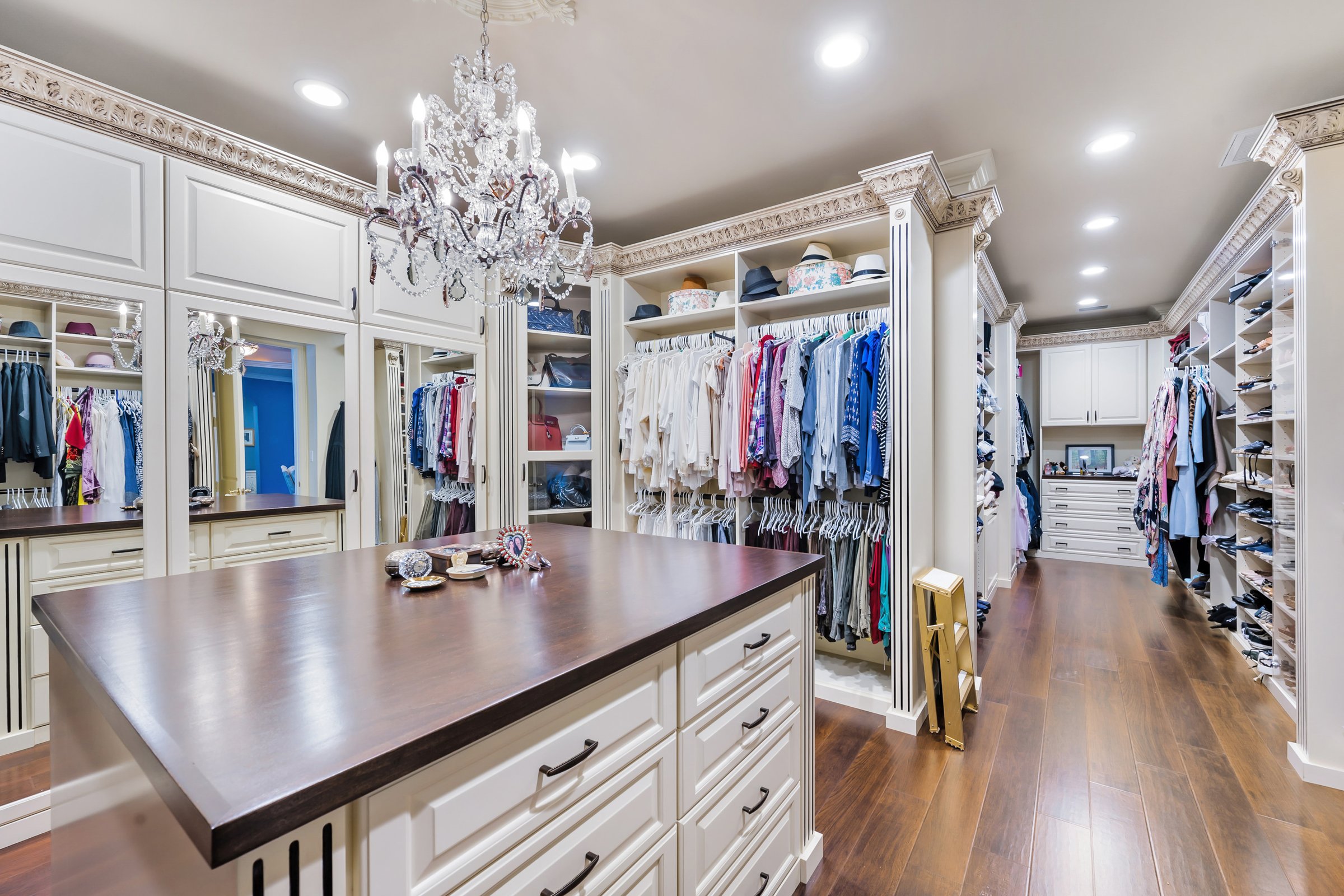 A dressing room with chandeliers and closets
