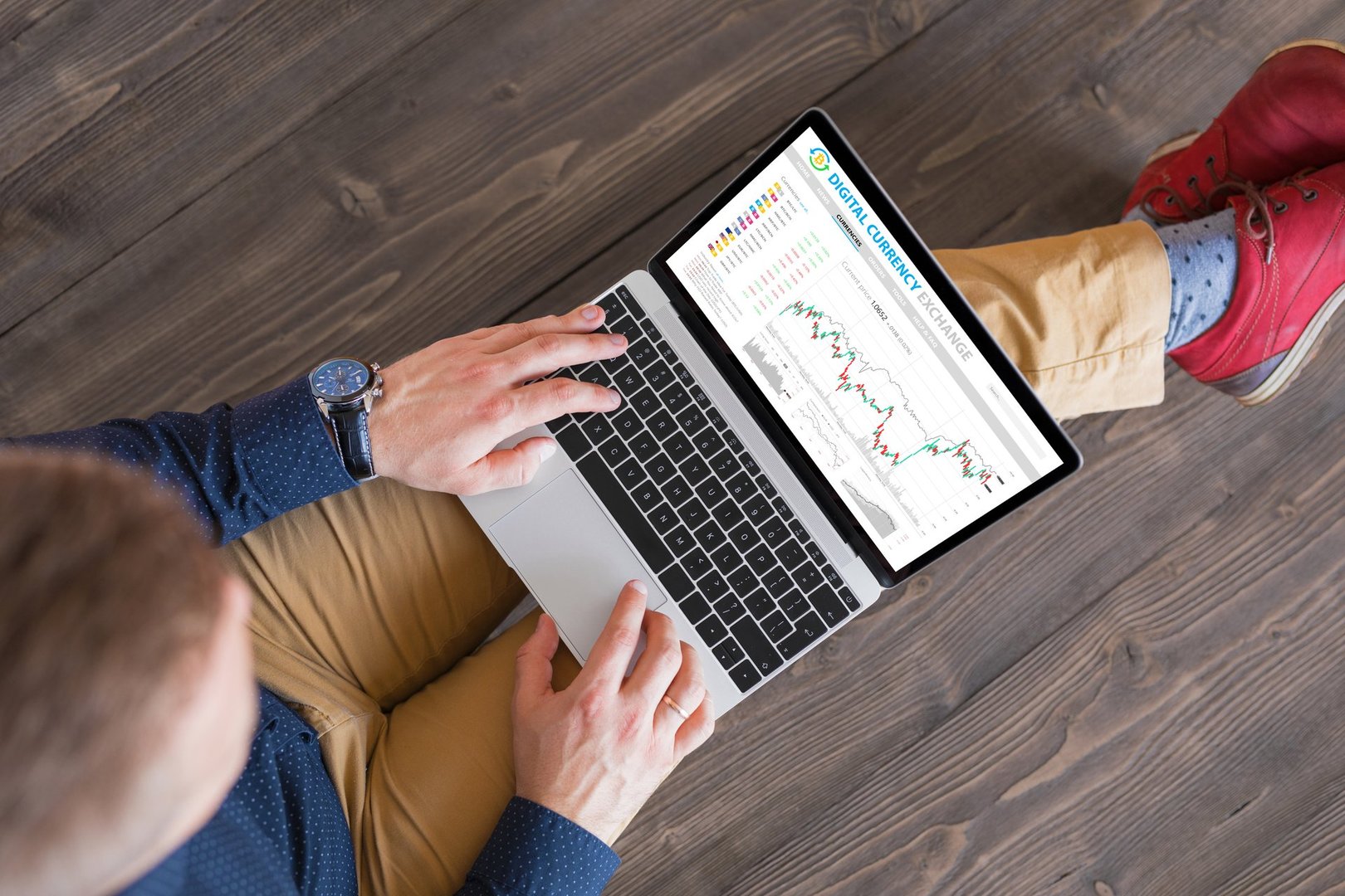 Unrecognizable male trading digital currencies online, top view.