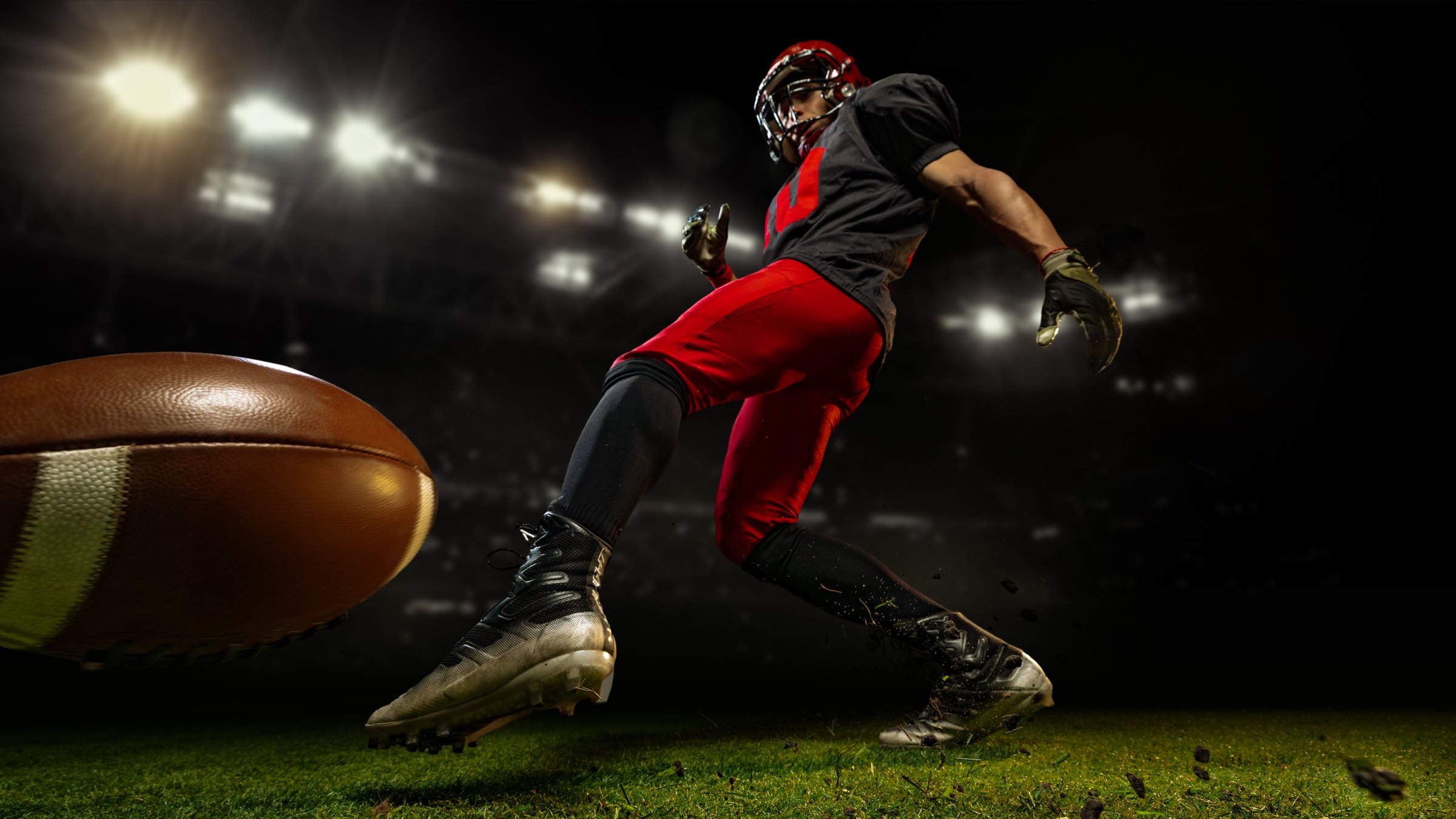 American football player kicking ball mid-motion under bright 3D stadium lights. Concept of action, discipline, and endurance for advertising, editorial, and sports branding visuals.