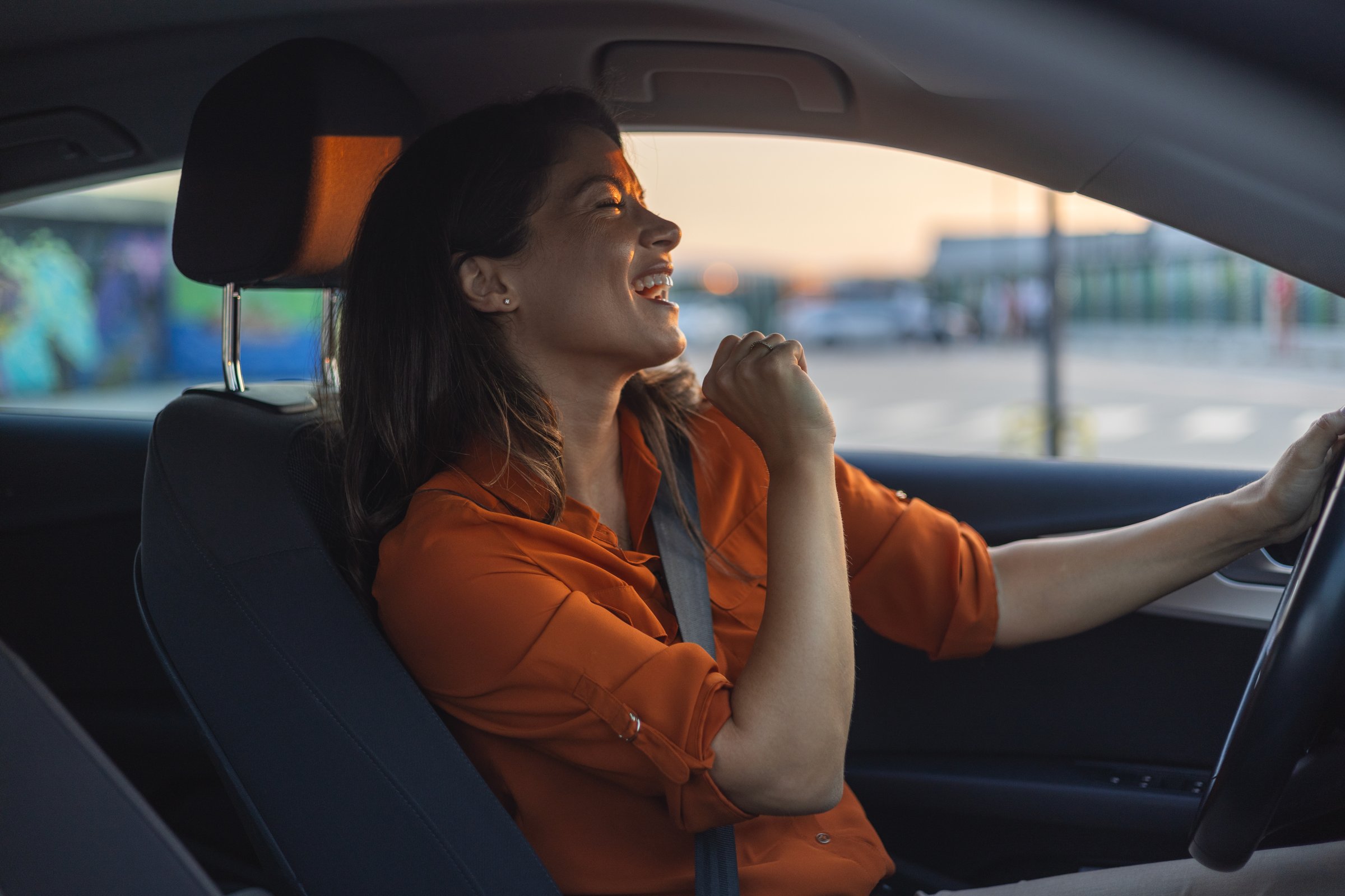 Close-up portrait of her she nice-looking attractive lovely brunette charming glad cheerful cheery girl riding new car enjoying having fun listening music singing pop rock