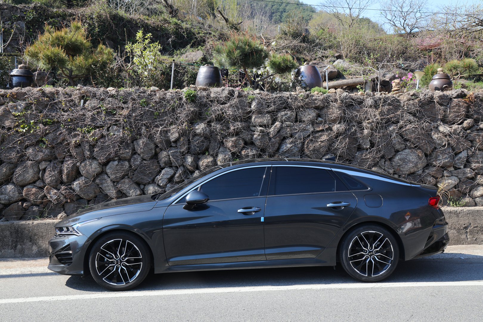 Kia Optima car also known as Kia K5, Korean mid-size sedan car parked along rural road.
