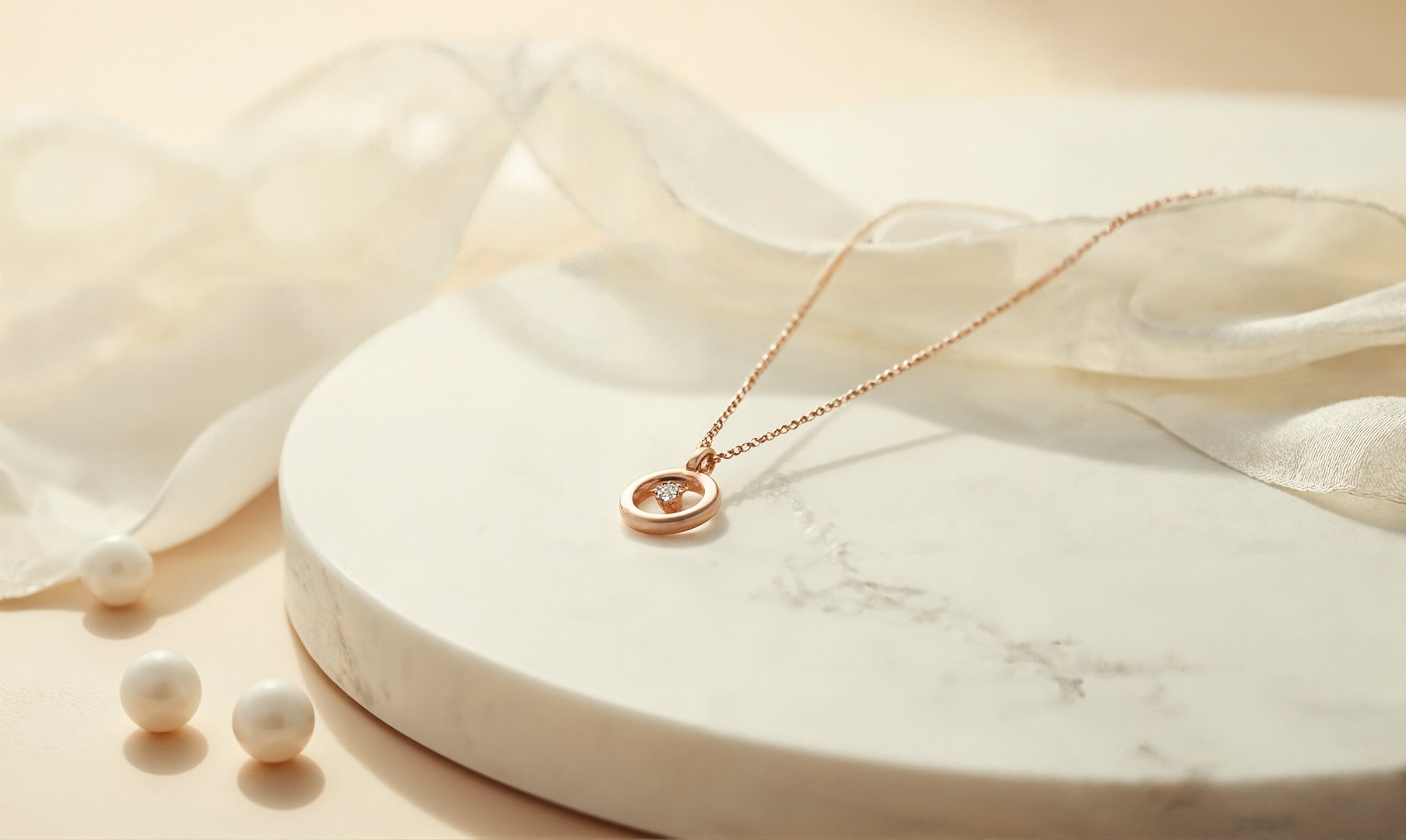 A refined rose gold pendant necklace with a brilliant-cut diamond, displayed on off-white marble. Soft lighting and minimalist elements create an elegant, modern aesthetic.