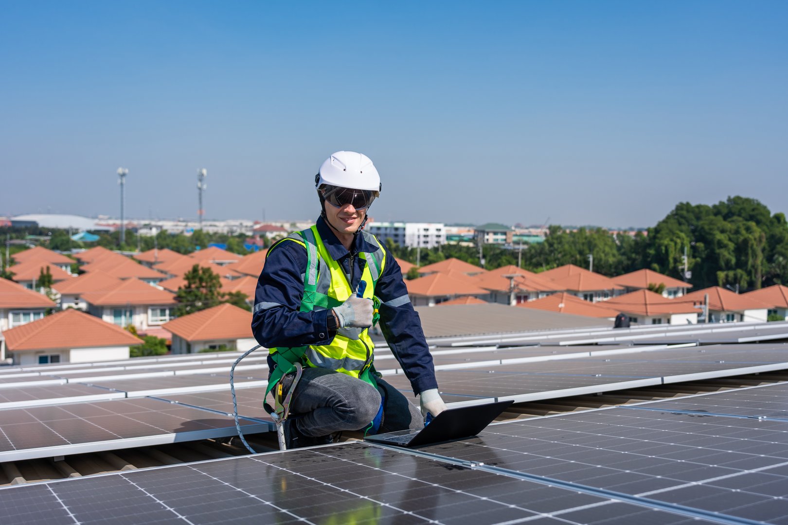 Professional engineer work to maintenance of photovoltaic panel system. Attractive technician worker working on roof inspect and check solar cell panels equipment box at solar cell field during sunset
