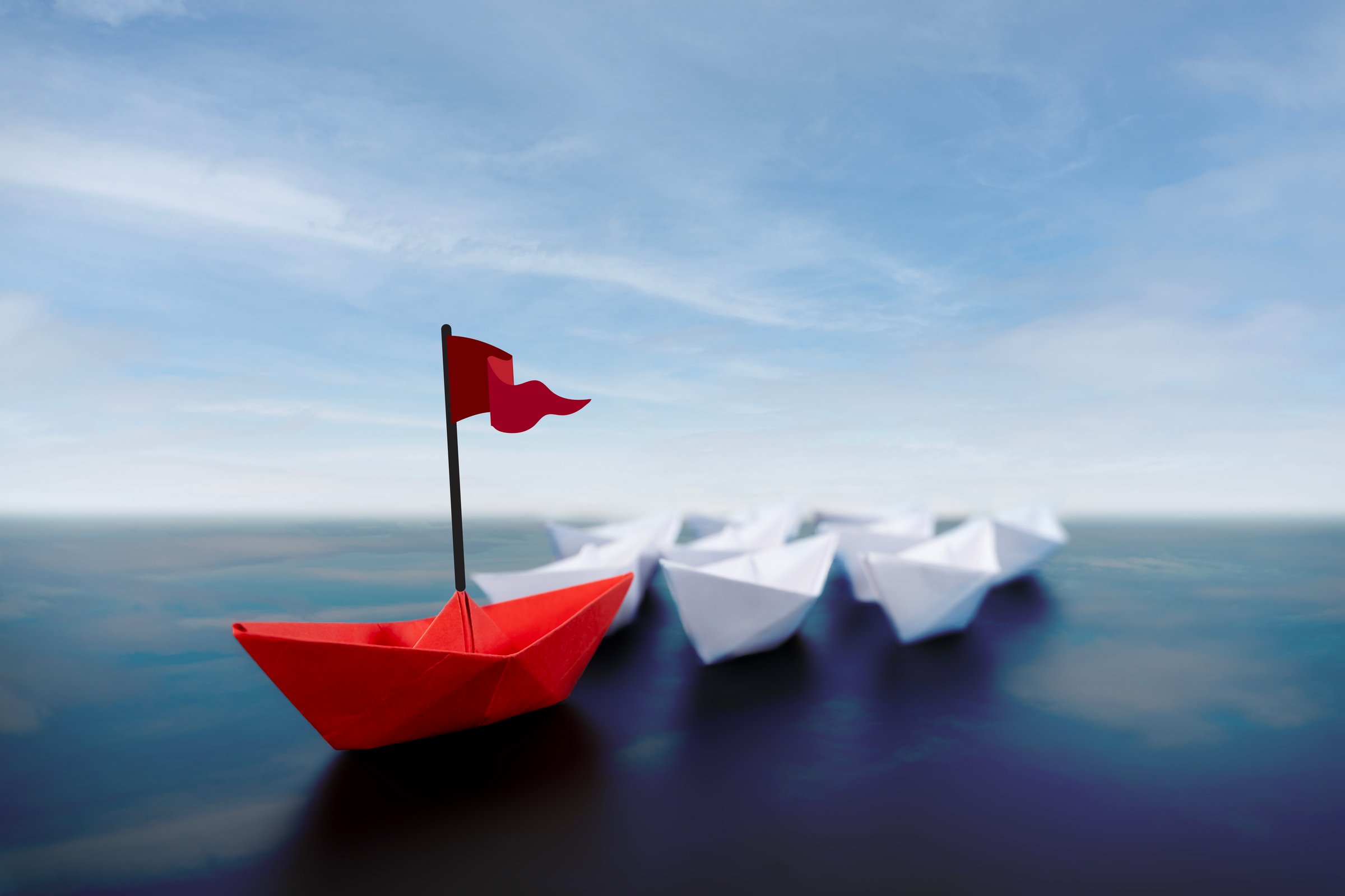Success leadership concept, Origami red paper boat floating in front of white paper boats on winding blue river, Paper art design banner background.  Business competition