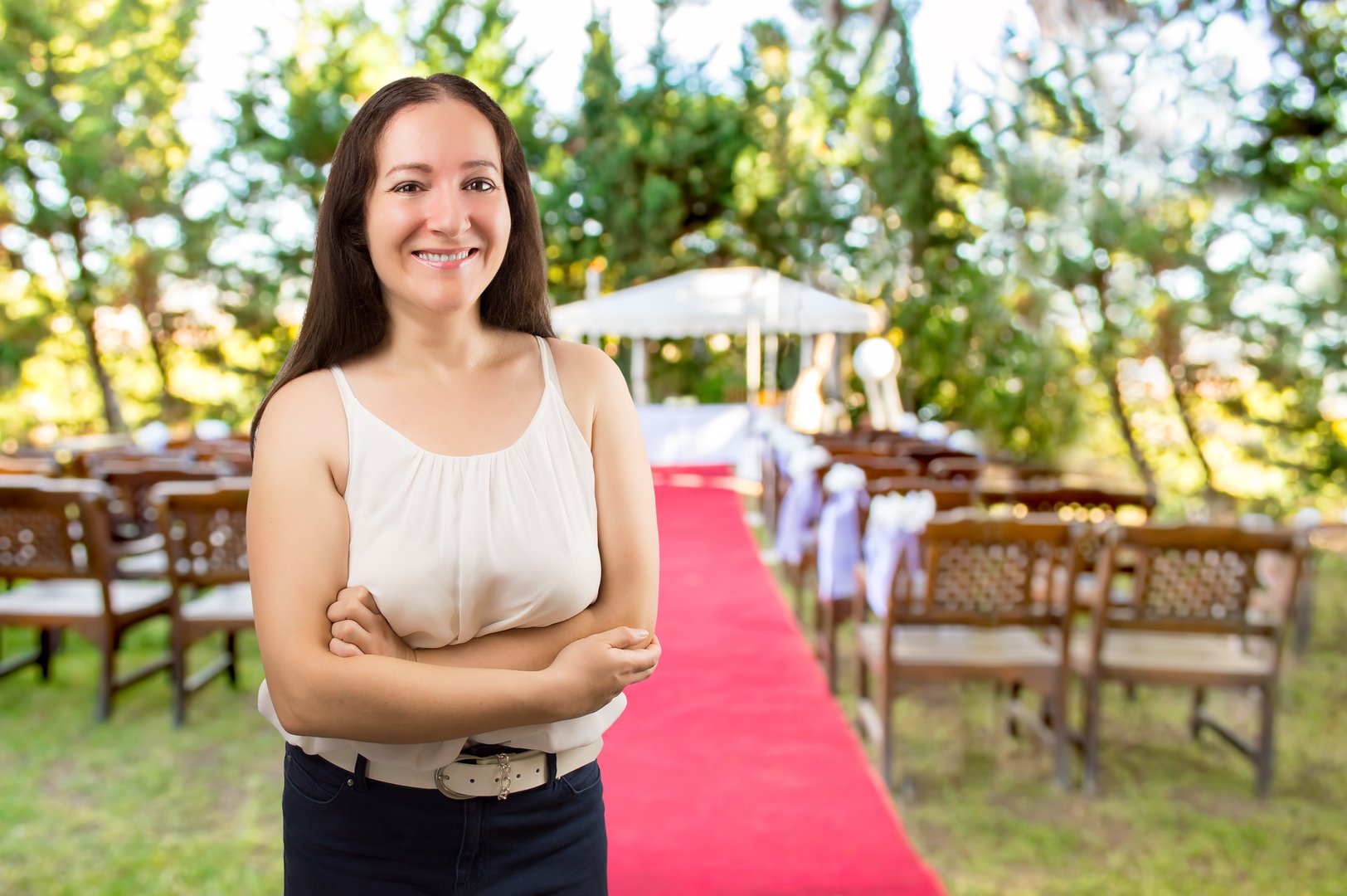 wedding planner woman is organizing the wedding reception venue for her customers standing and smiling at the wedding place