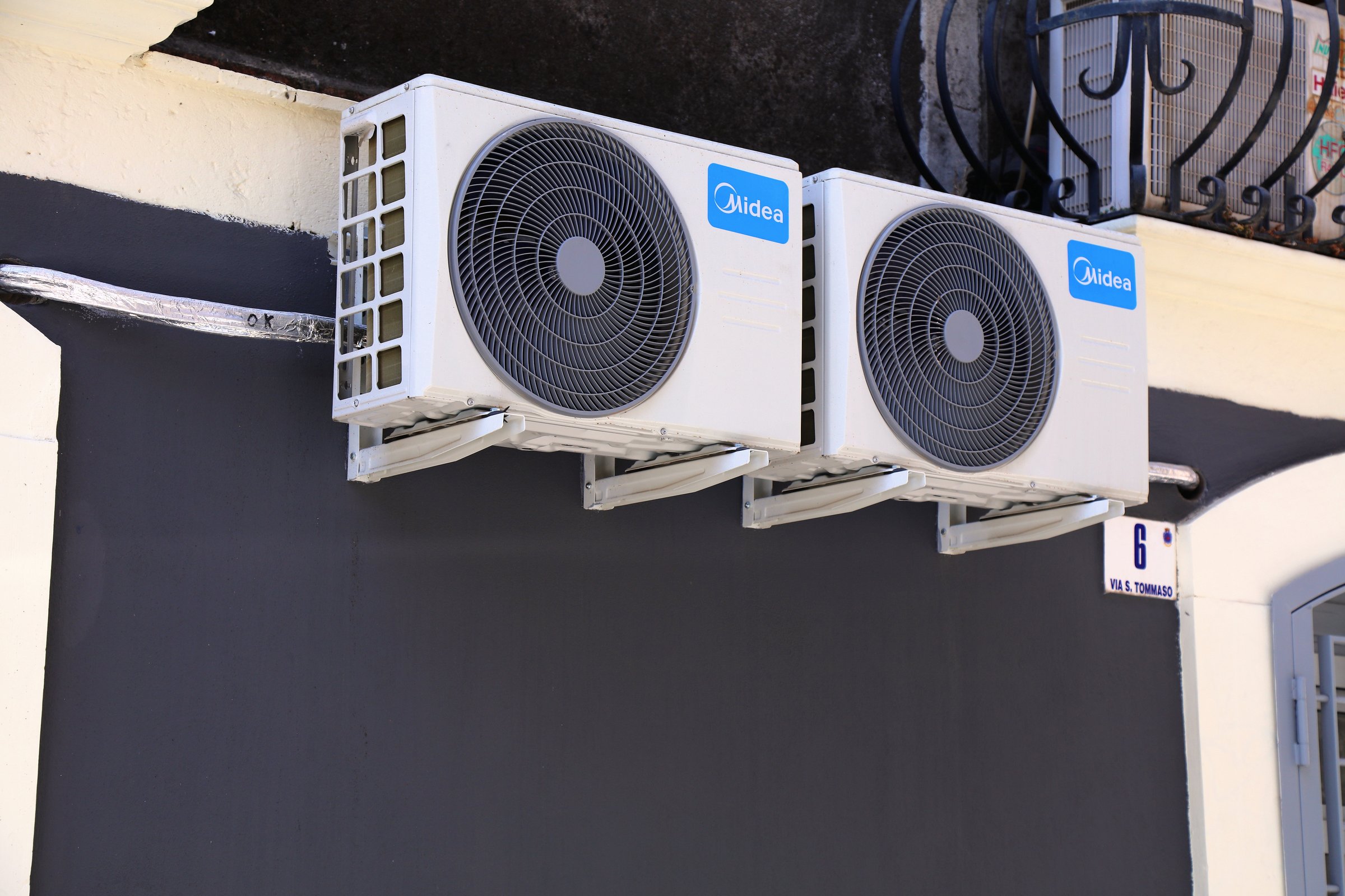 Public street view of Midea brand wall mounted air conditioner unit in Catania city on Sicily island, Italy.