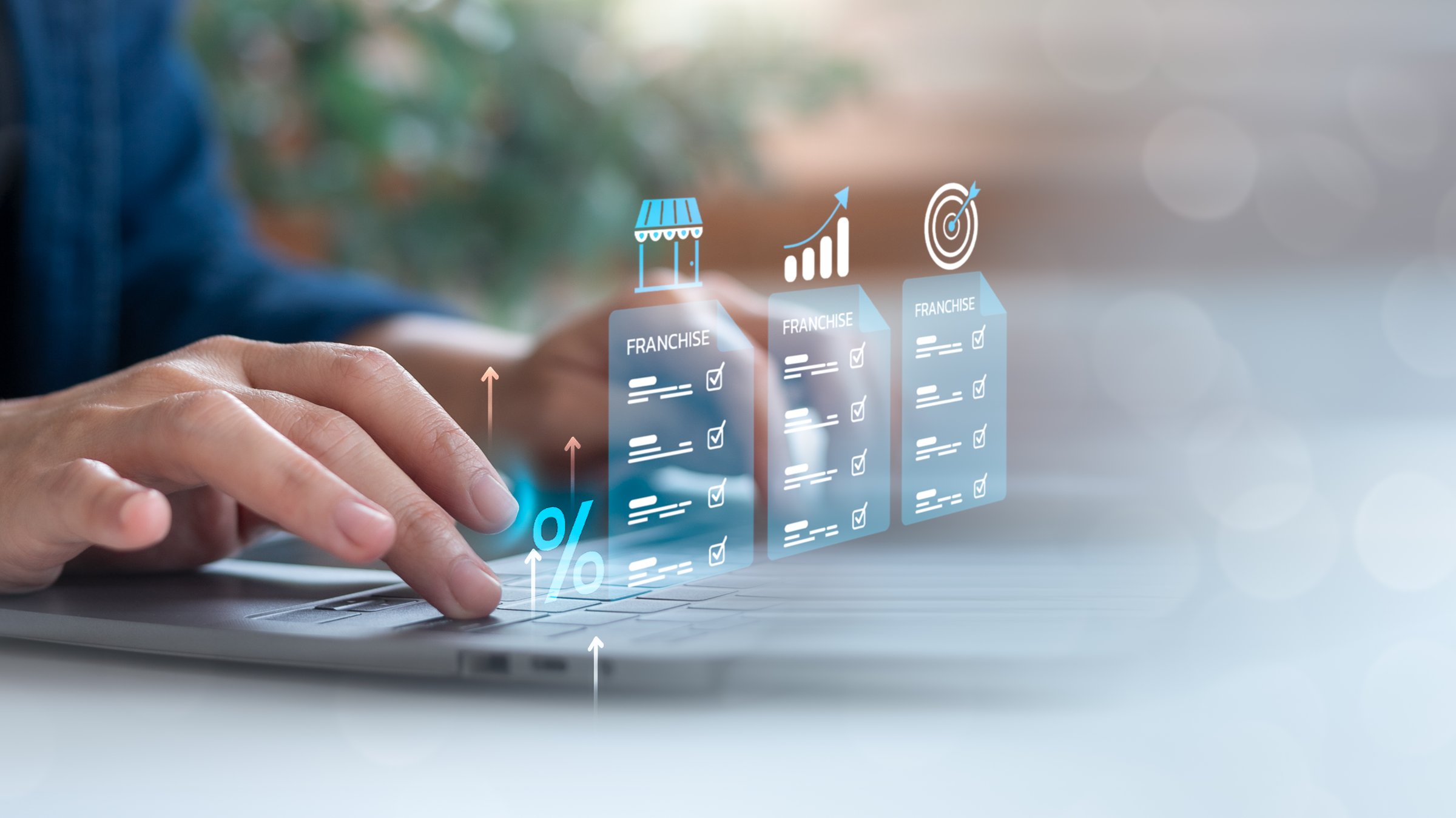 Hands typing on a laptop with holographic franchise documents, growth chart, and target icon. Concept of franchise investment analysis and business opportunity review.
