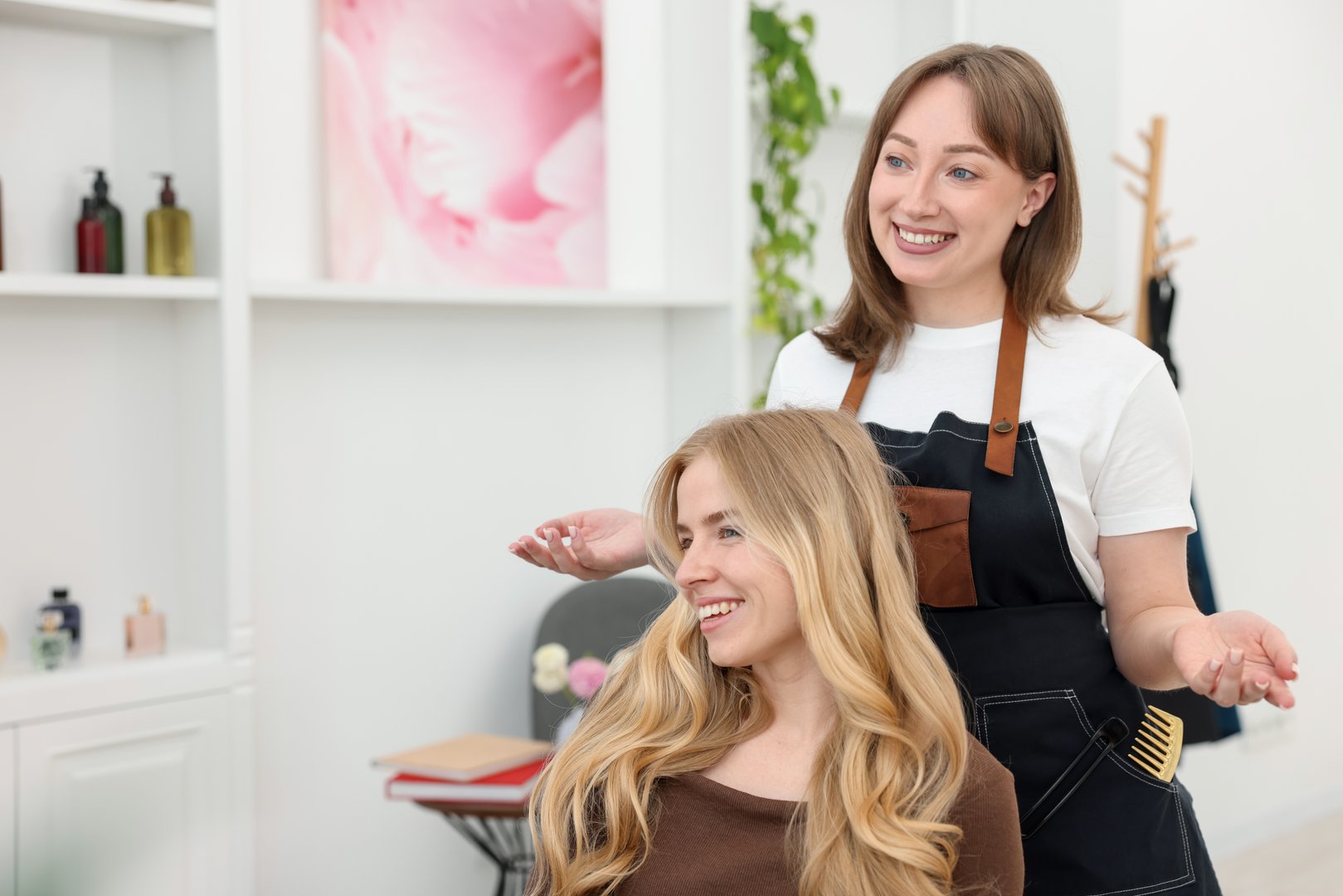 Professional hairstylist working with client in salon, space for text