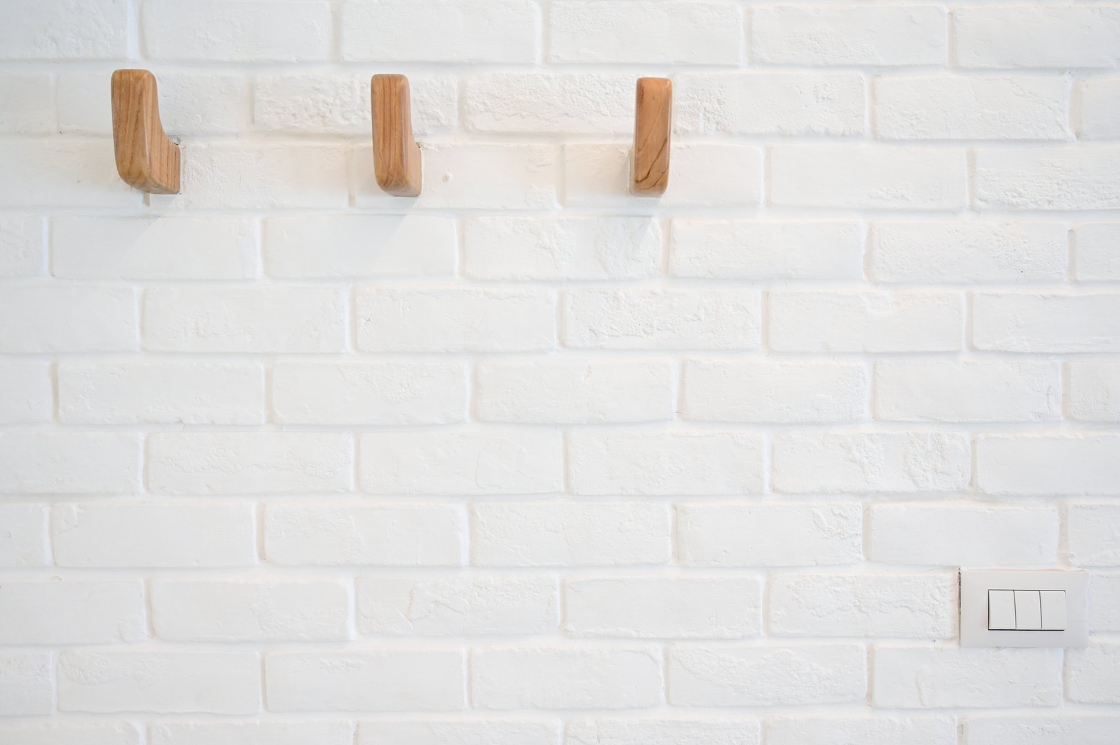wooden hanger hook on white brick wall